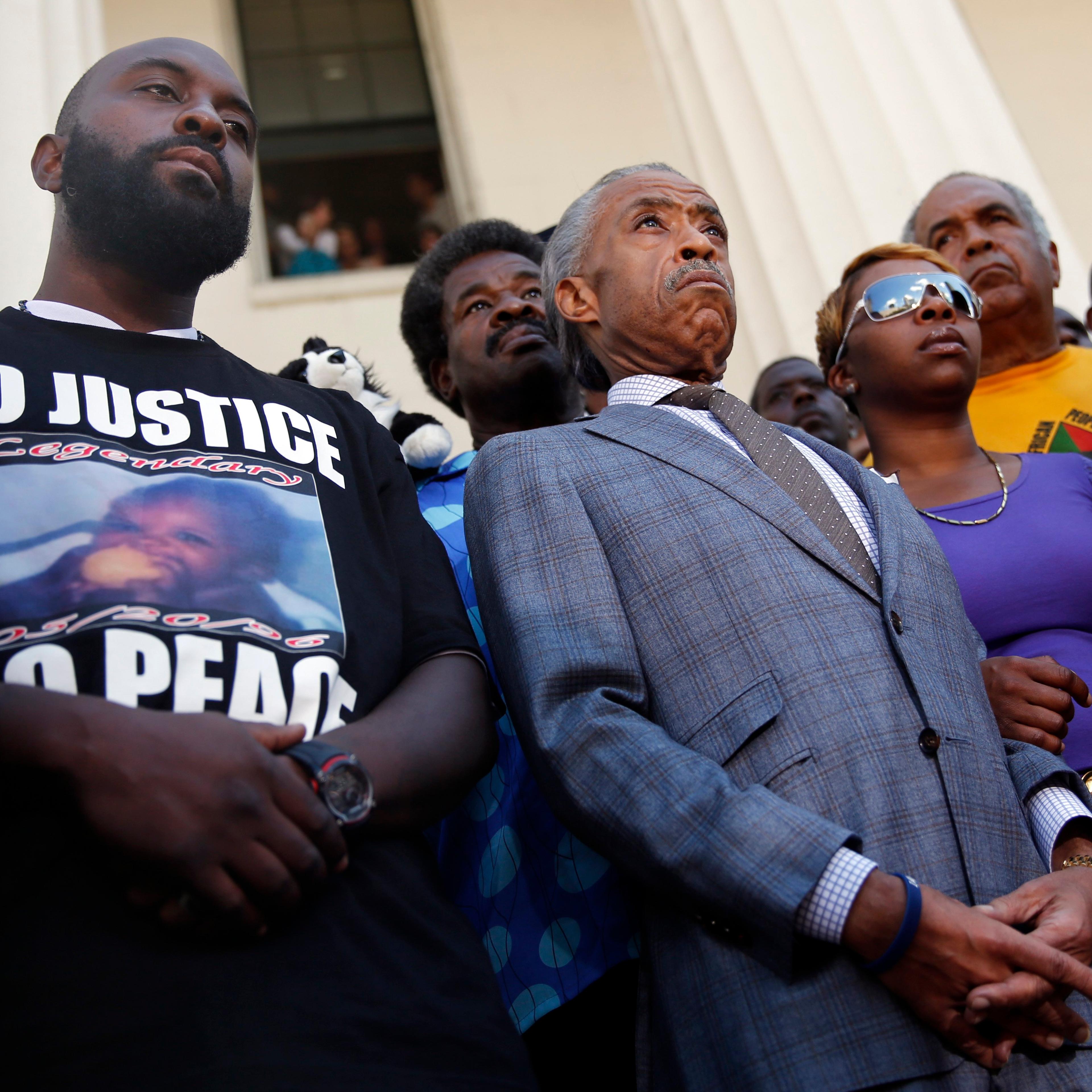 From left: Michael Brown, Sr., Reverend Al Sharpton, and Lesley McSpadden during a news conference outside the Old Courthouse in St. Louis on Aug. 12, 2014.