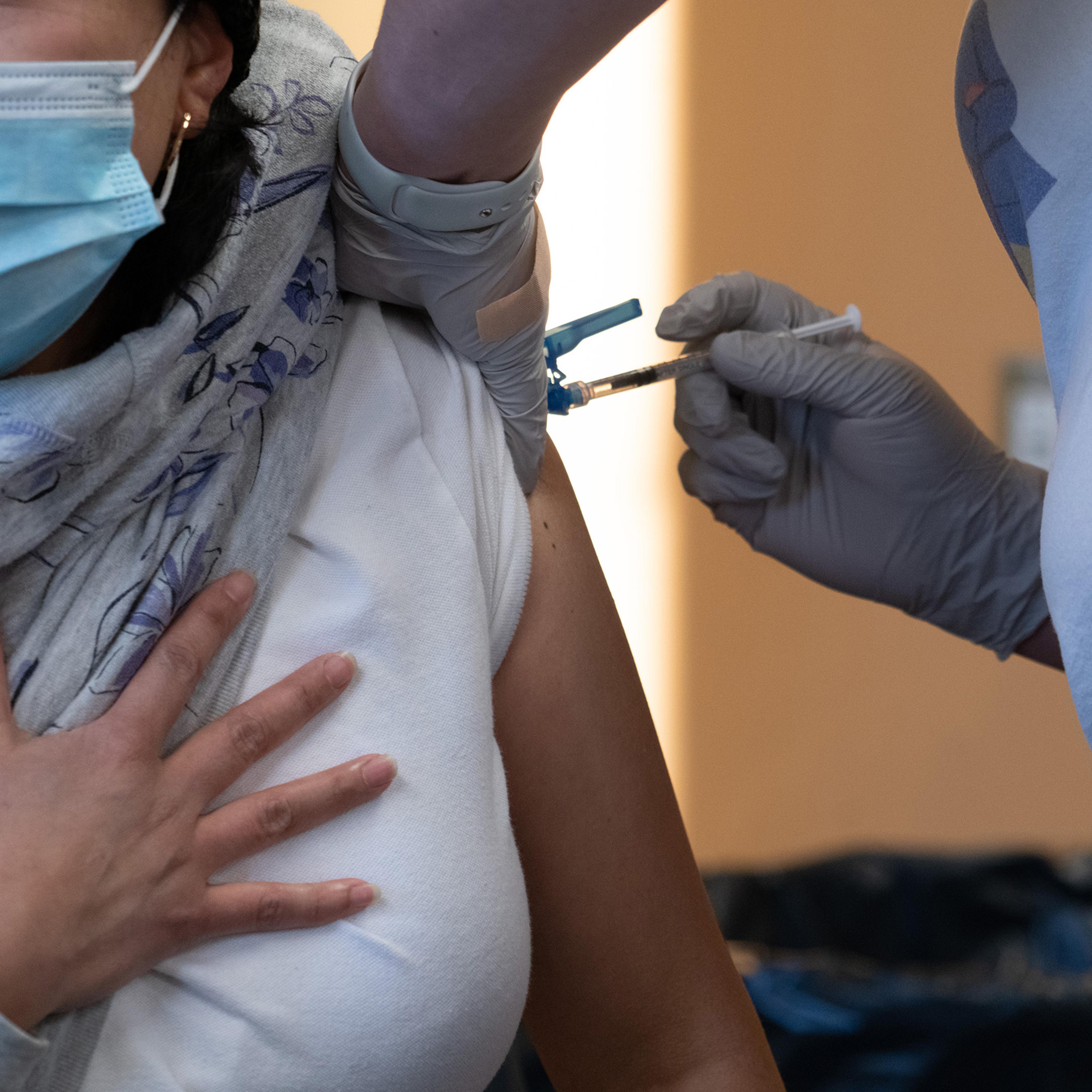 A healthcare worker administers a dose of the Pfizer-BioNTech Covid-19 vaccine at a vaccination clinic in Peabody, Mass., on Jan. 26, 2022.
