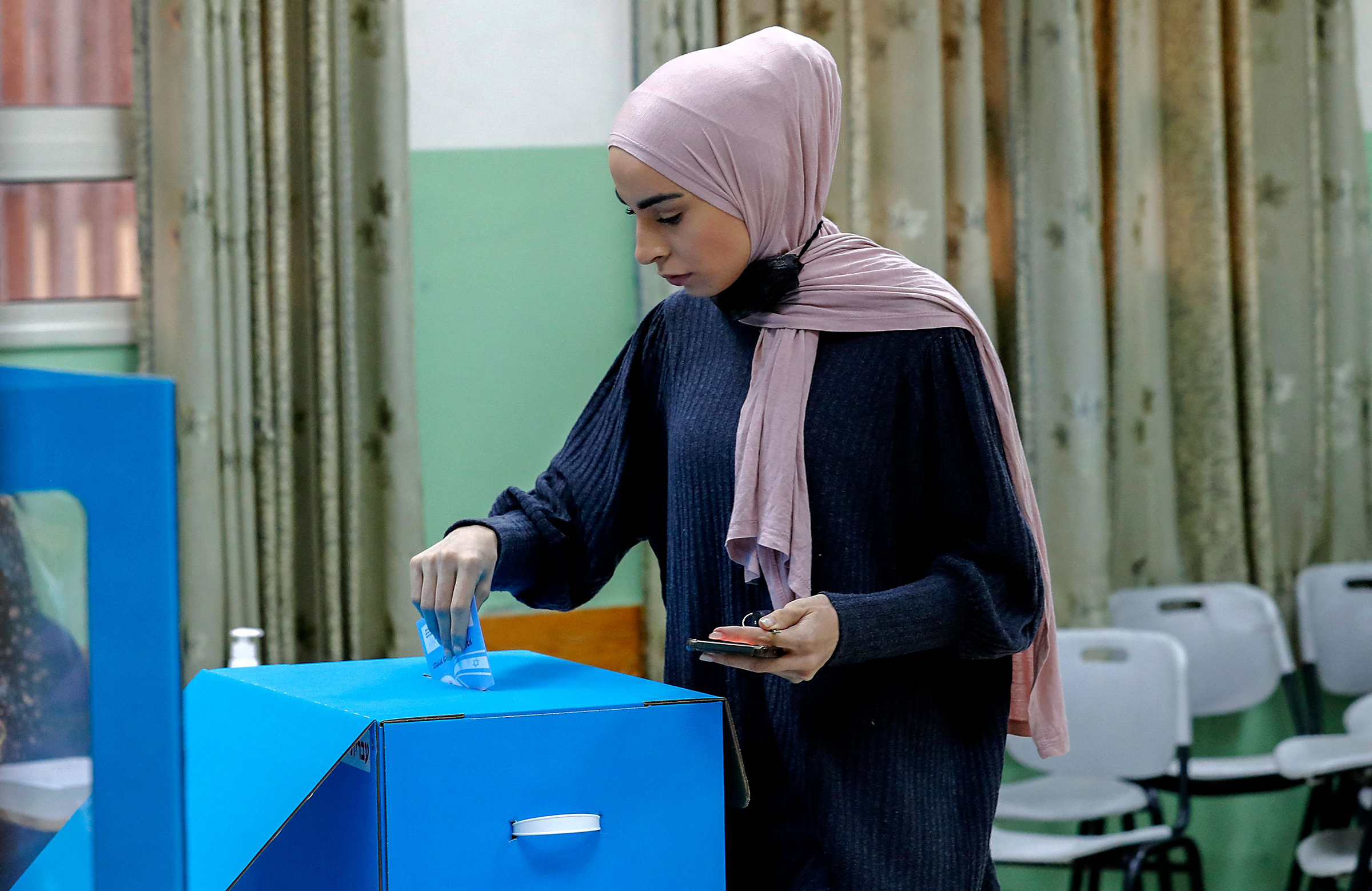 An Israeli Arab voter casts her ballot at a polling station in Kafr Manda, 16 kilometers northwest of the city of Nazareth, on March 23, 2021.