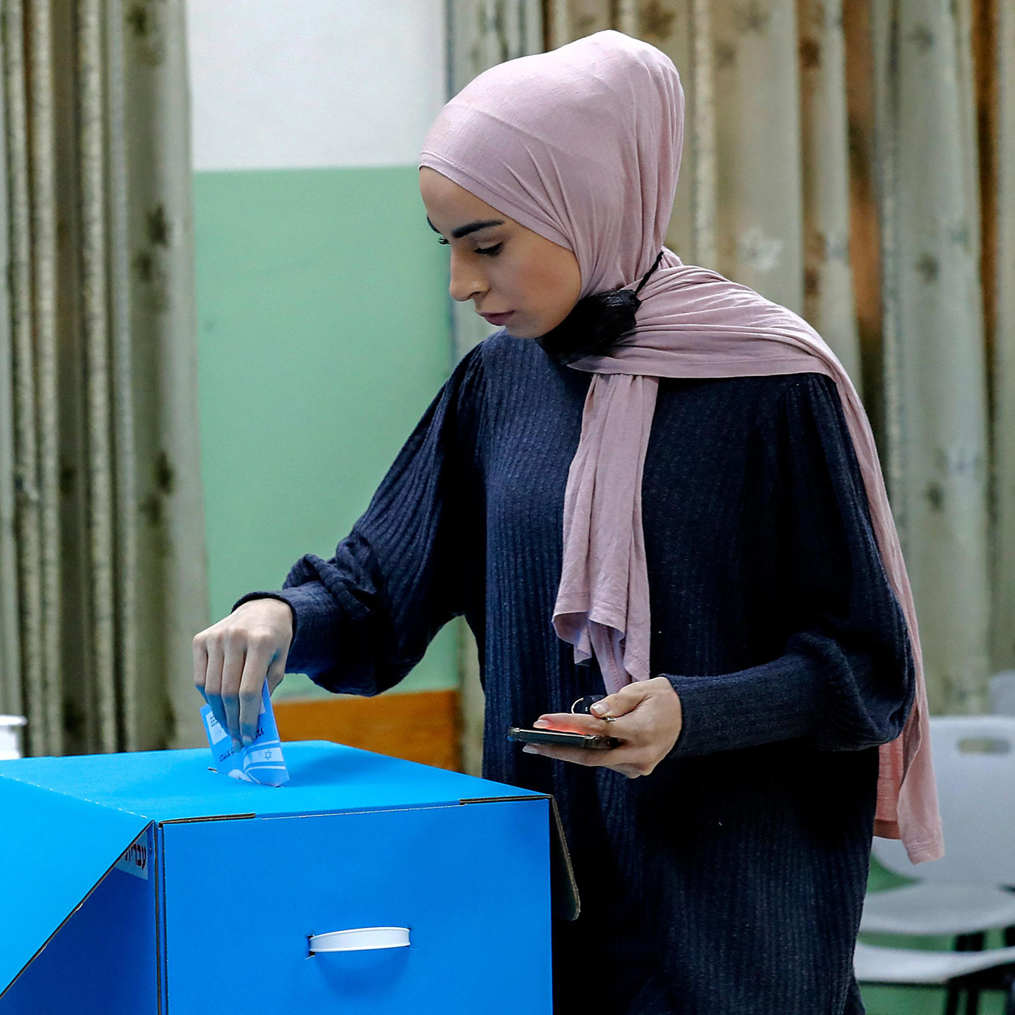 An Israeli Arab voter casts her ballot at a polling station in Kafr Manda, 16 kilometers northwest of the city of Nazareth, on March 23, 2021.
