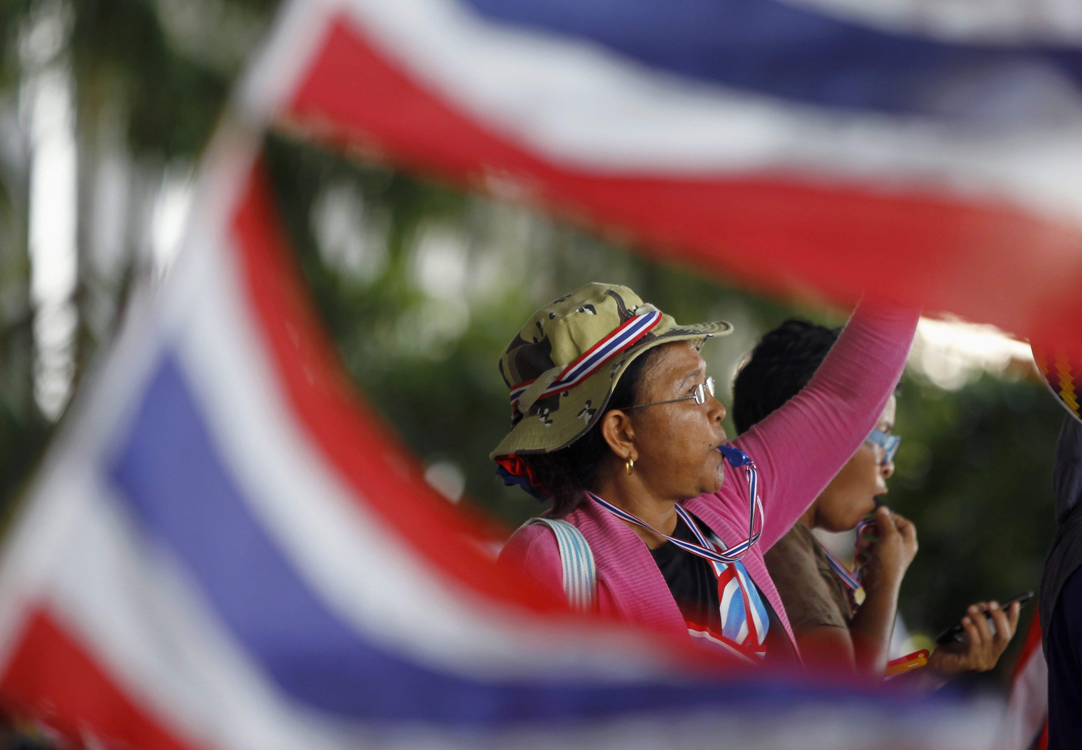 An anti-government protester blows her whistle during a rally outside the office of Election Commission in Bangkok May 15, 2014.