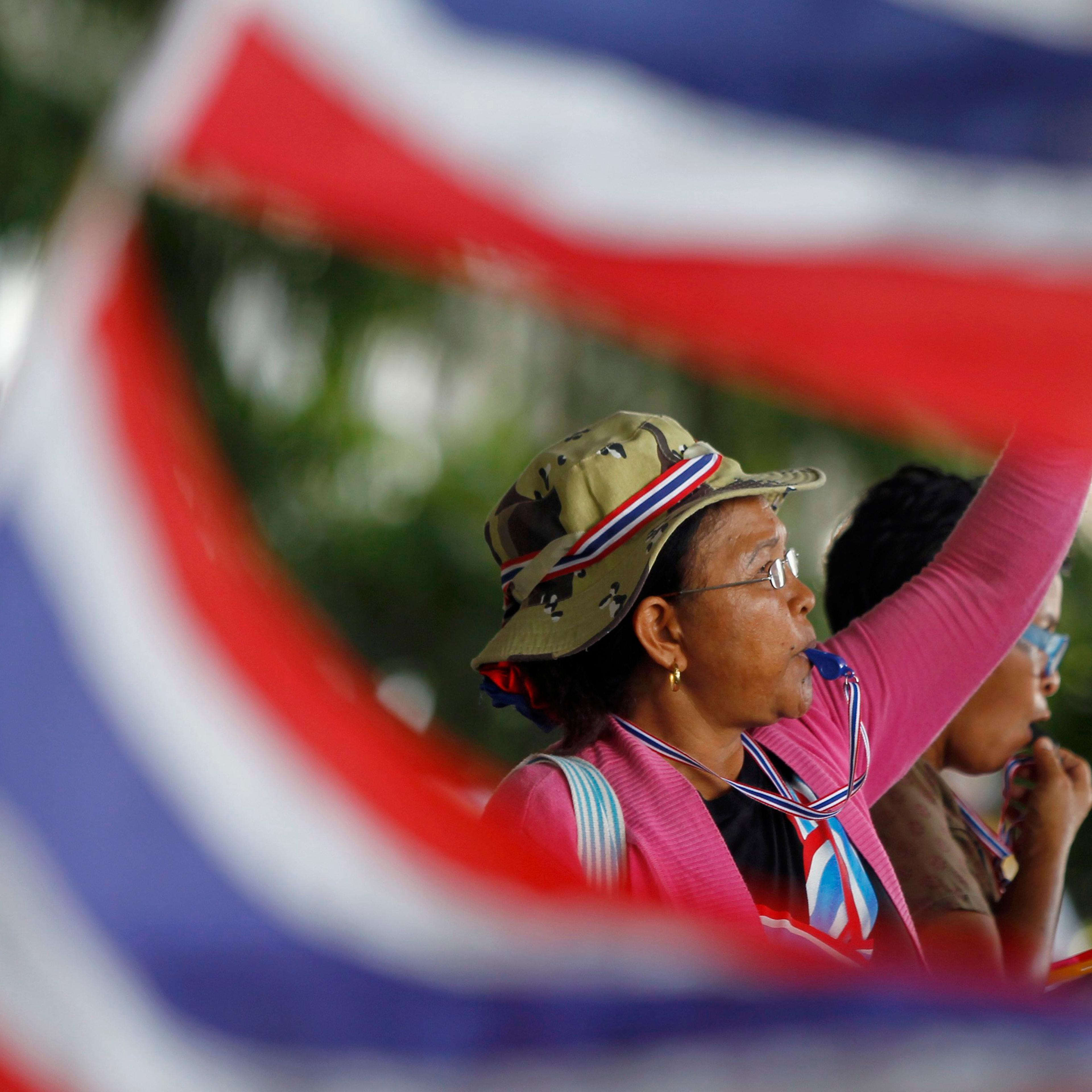 An anti-government protester blows her whistle during a rally outside the office of Election Commission in Bangkok May 15, 2014.