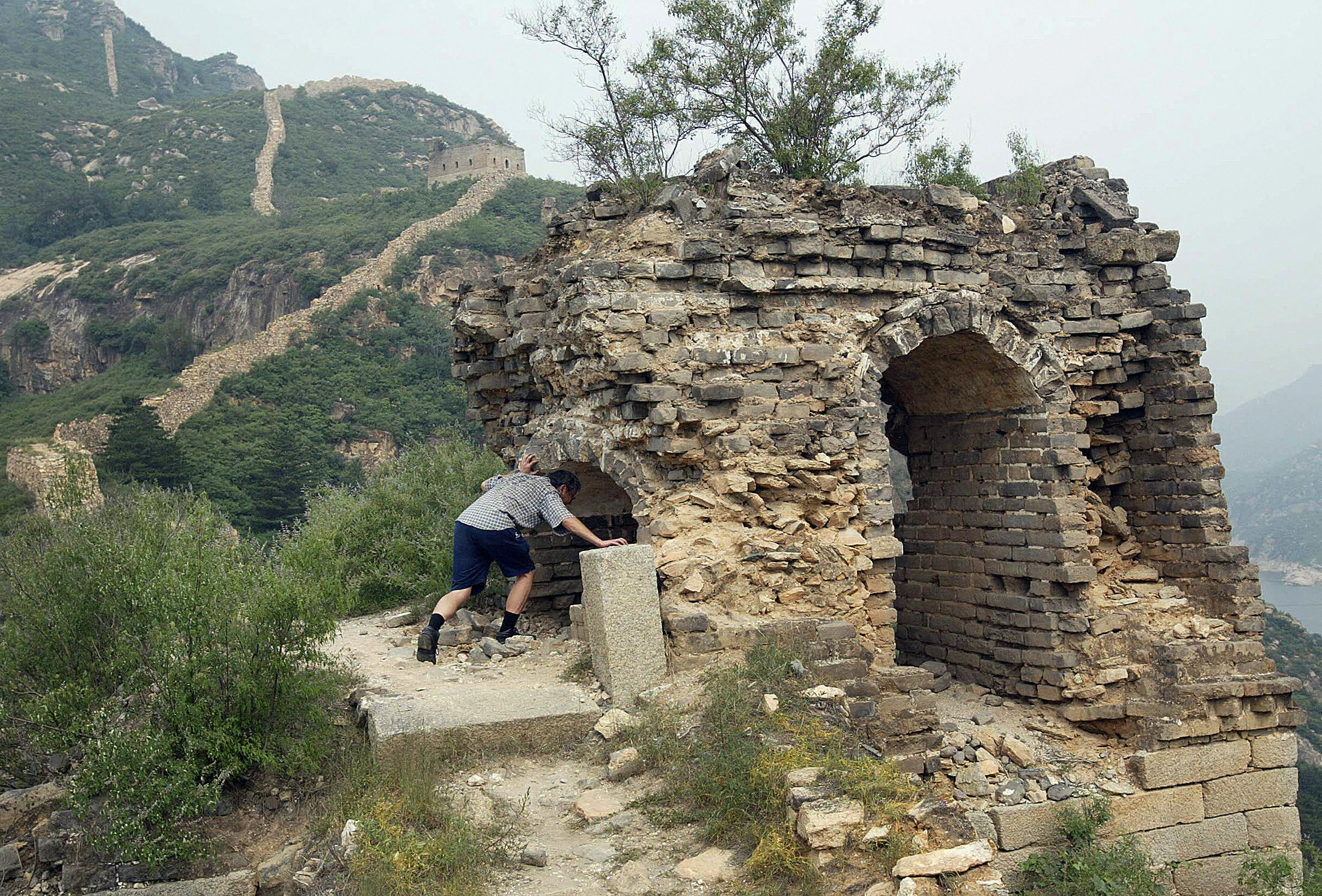 A man enters a crumbling structure along