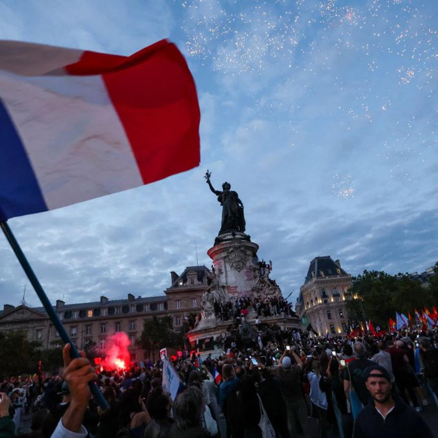 A participant waves a French national tricolor during an election night rally following the first results of the second round of France's legislative election at Place de la Republique in Paris on July 7, 2024.
