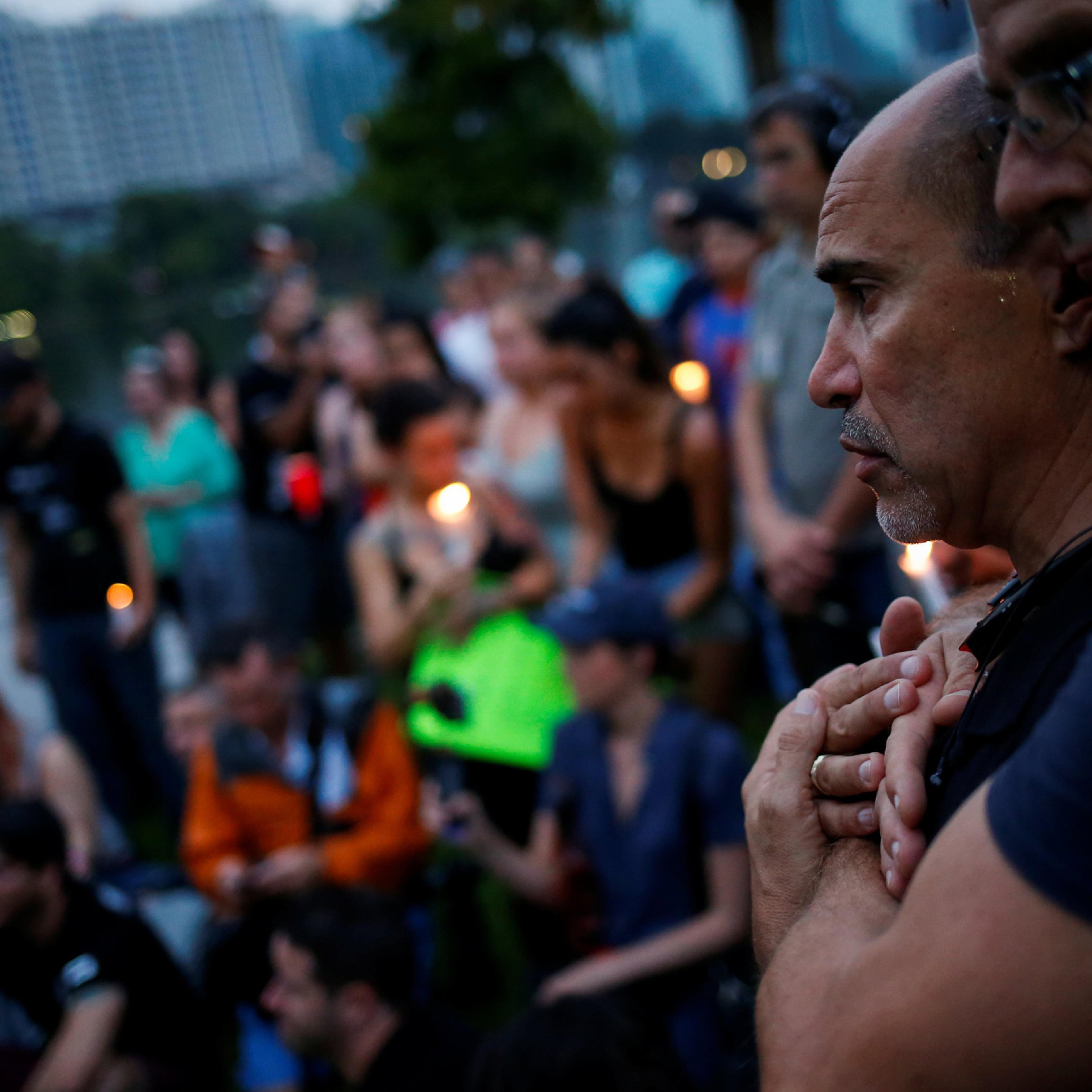 Wilfredo Perez (L), a local bartender at a gay bar, is embraced by his partner Jackson Hollman during a vigil to commemorate victims of a mass shooting at the Pulse gay night club in Orlando, June 12, 2016.