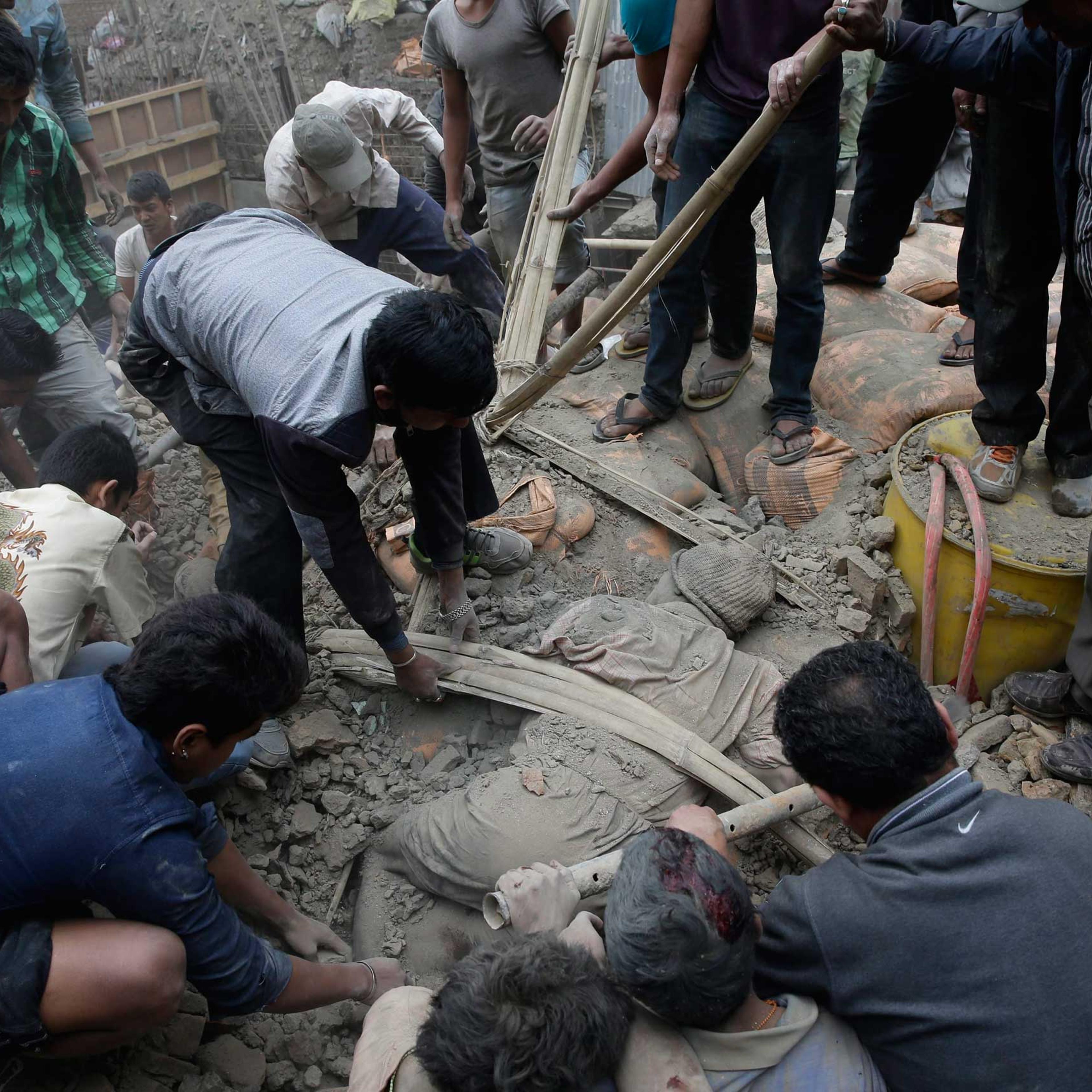 People try to free a man from the rubble of a destroyed building after an earthquake in Kathmandu, Nepal on April 25, 2015.