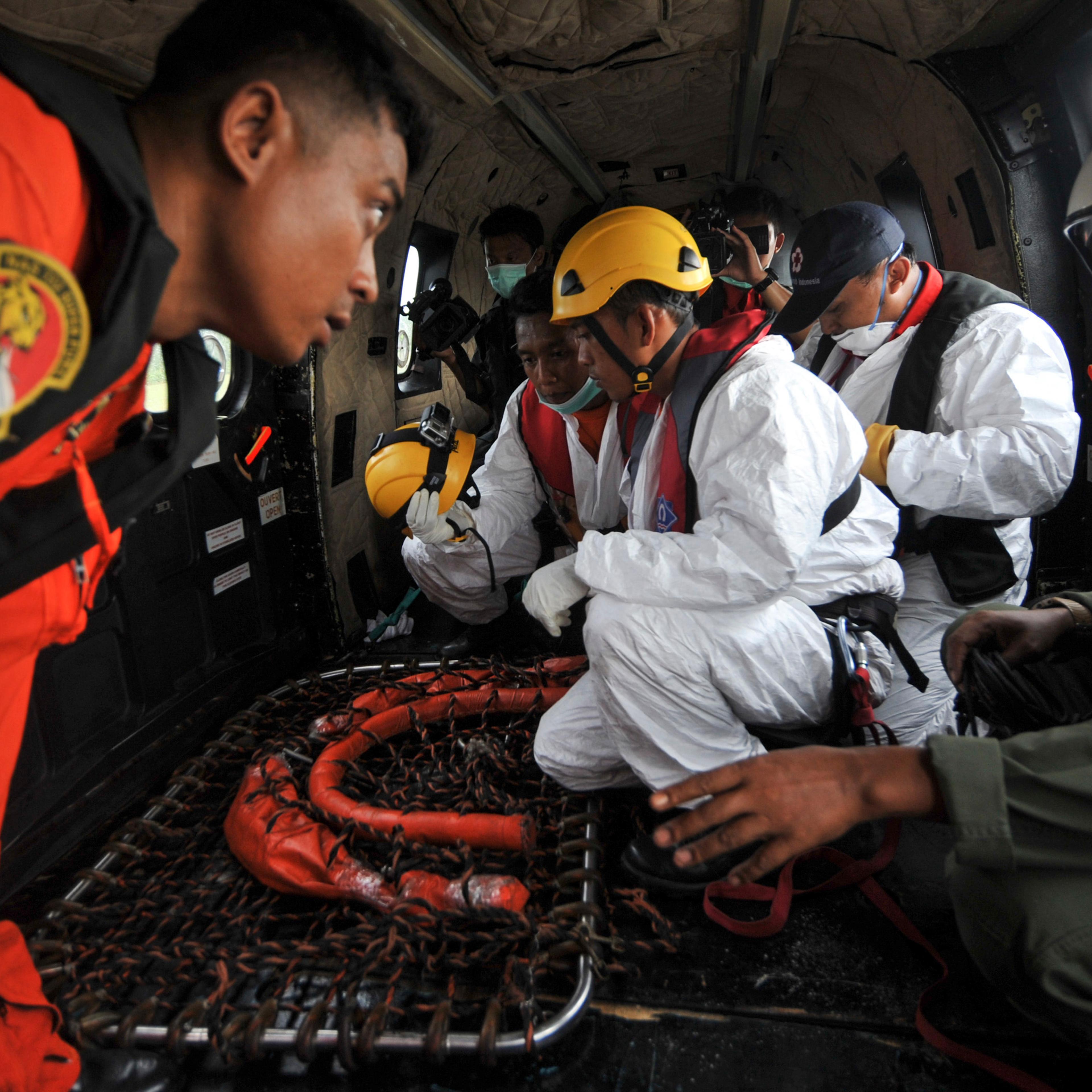 Search and rescue teams and flight crew prepare their gear on board an Indonesian Air Force Super Puma helicopter before a search mission for debris and bodies from AirAsia flight QZ8501at Iskandar Air Force Base, in Pangkalan Bun