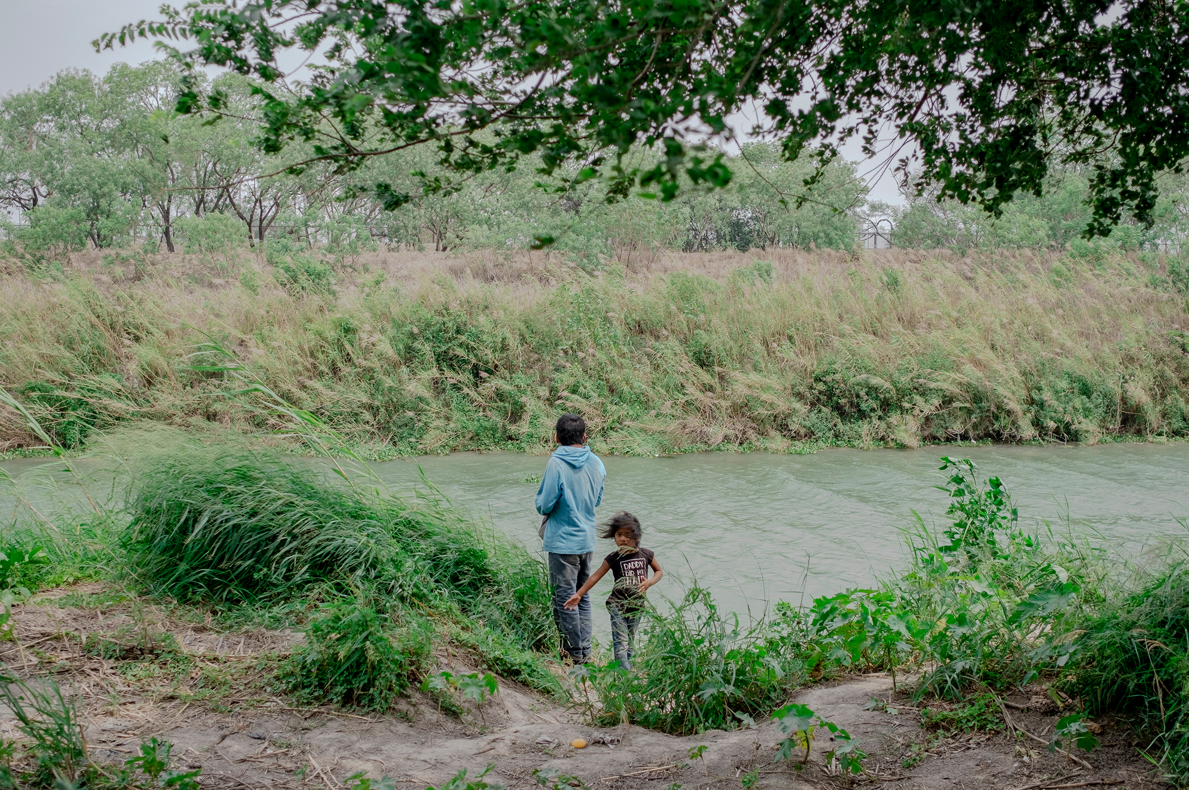 Asylum seekers on the bank of the Rio Grande in Matamoros, Mexico, on April 22. In the city just over the U.S. border from Brownsville, Texas, roughly 2,500 asylum seekers await their court dates living on a muddy strip of land the size of two football f