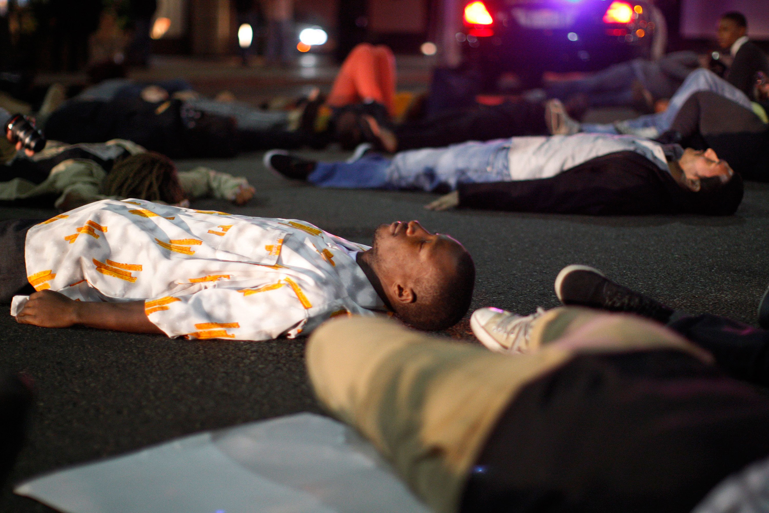 Protesters lay down to block traffic in the intersection of Wilshire Boulevard and Rodeo Dr. in Beverly Hills, Calif., on Nov. 24, 2014.