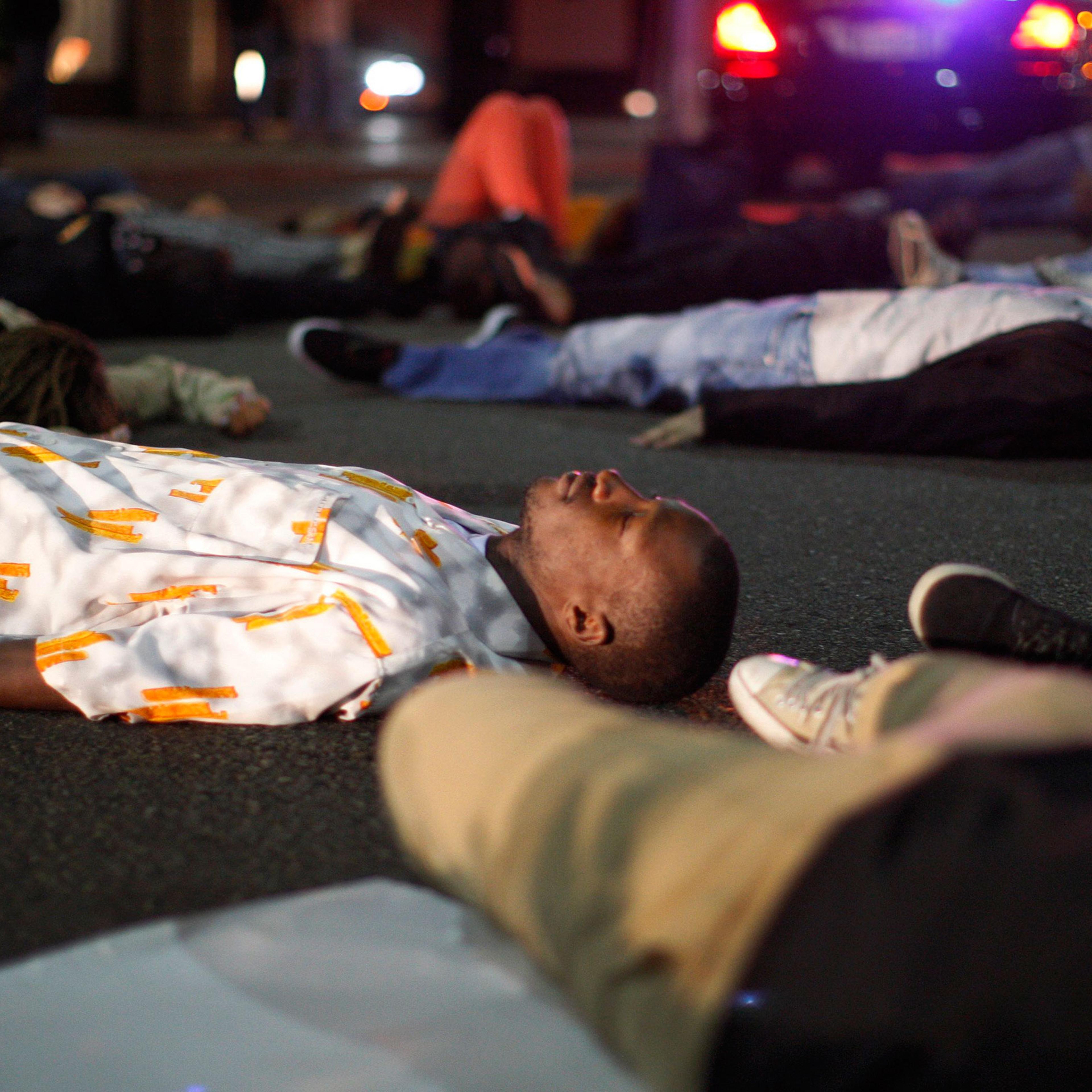 Protesters lay down to block traffic in the intersection of Wilshire Boulevard and Rodeo Dr. in Beverly Hills, Calif., on Nov. 24, 2014.
