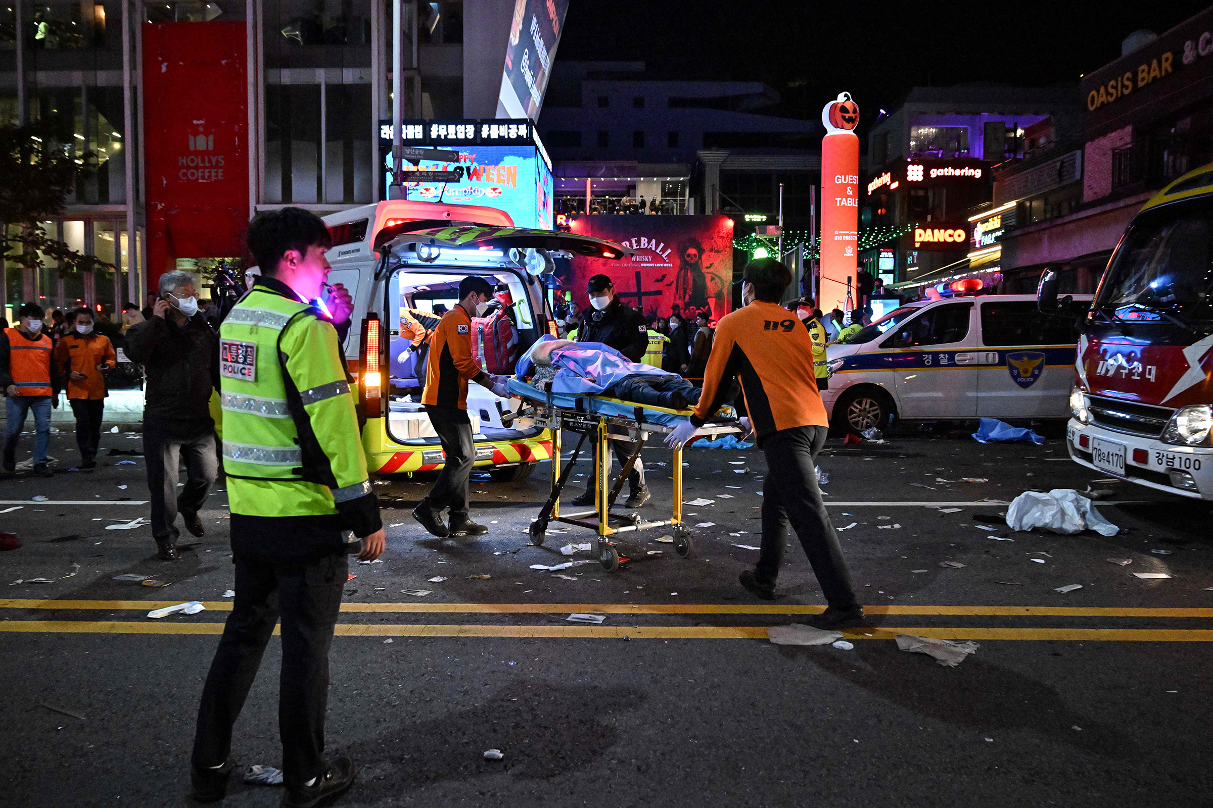 A person, believed to have suffered from cardiac arrest, is transported into an ambulance in the popular district of Itaewon in Seoul amidst Halloween celebrations on Oct. 30. 