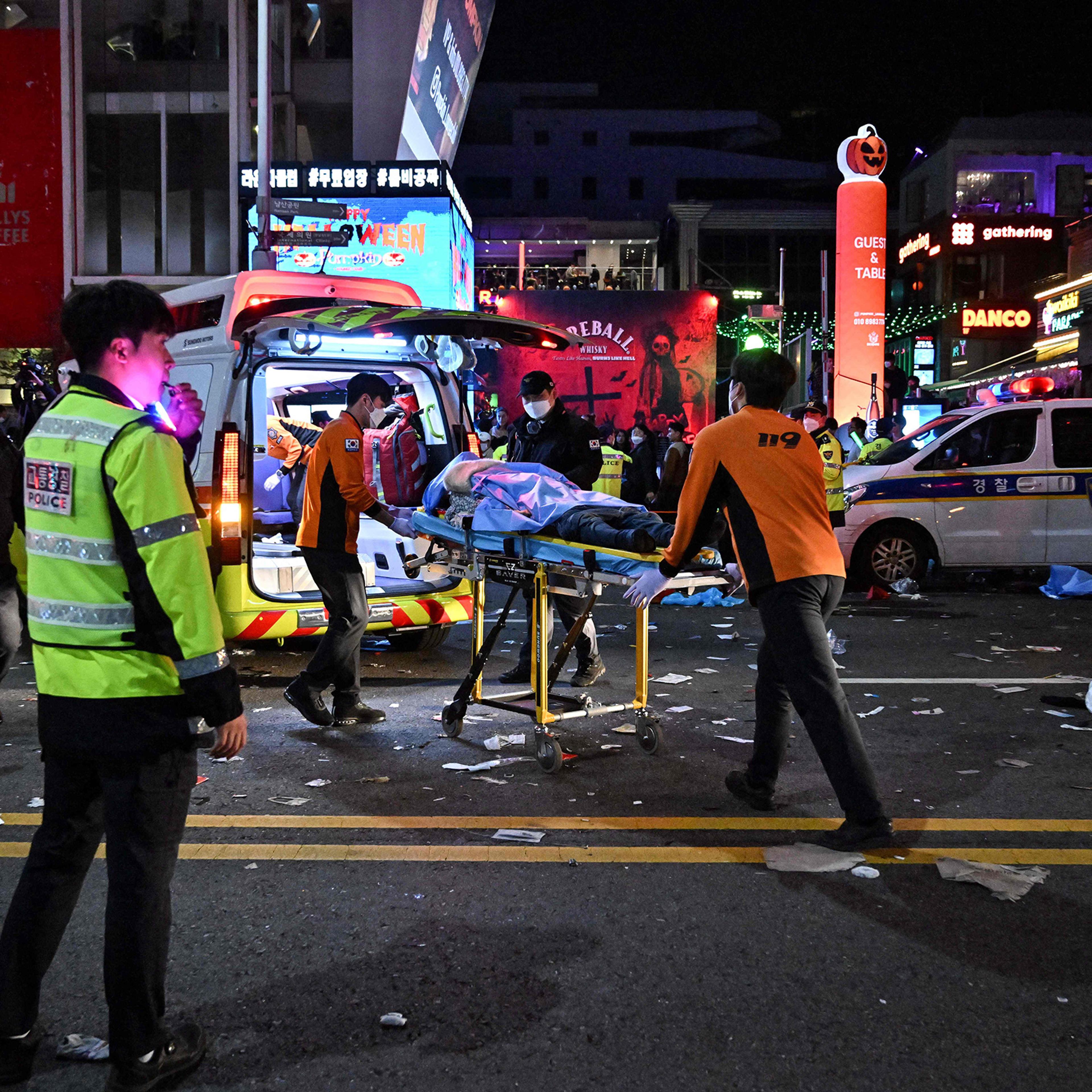 A person, believed to have suffered from cardiac arrest, is transported into an ambulance in the popular district of Itaewon in Seoul amidst Halloween celebrations on Oct. 30.