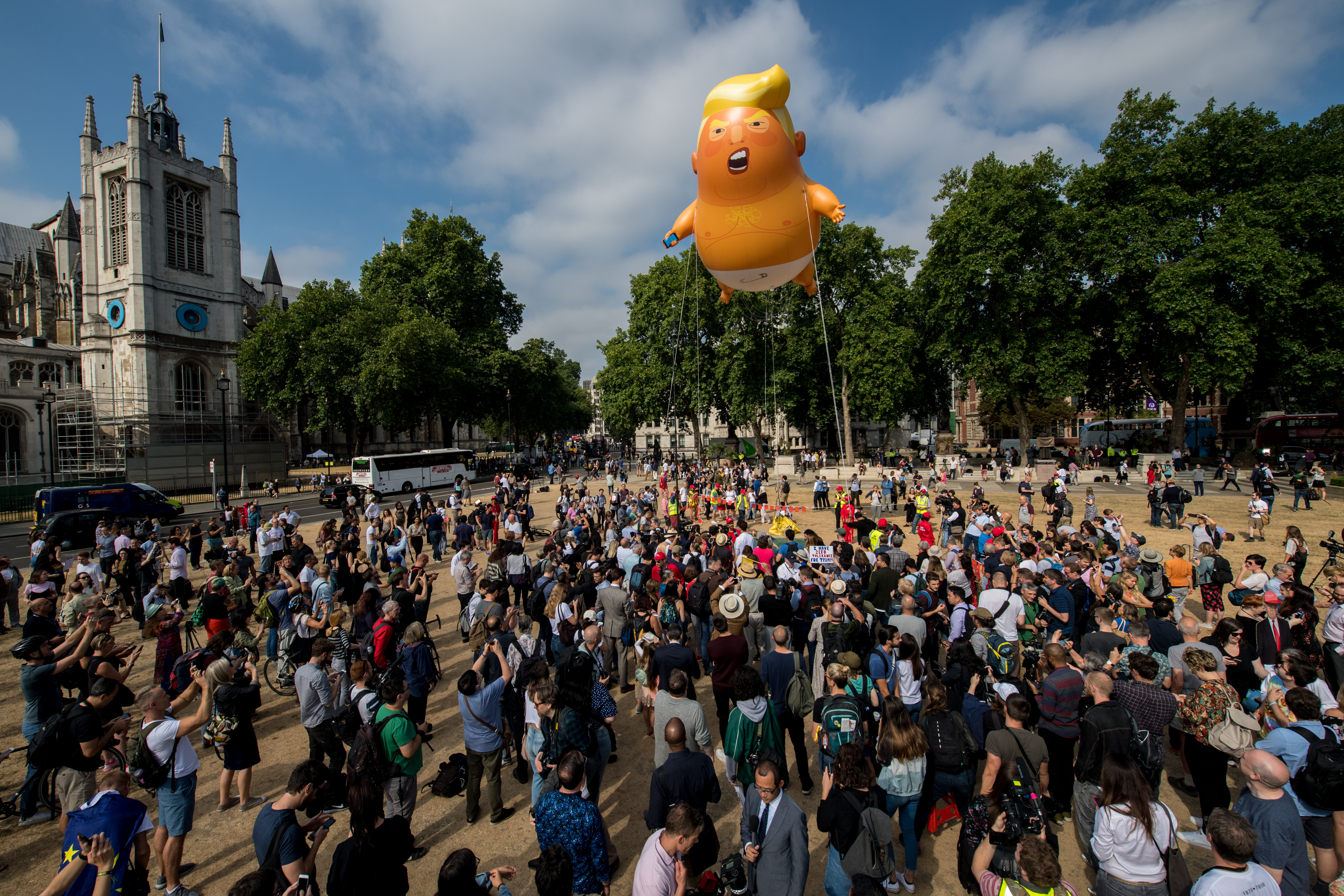 Demonstrators raise a six meter high effigy of Donald Trump, being dubbed the 'Trump Baby', in Parliament Square in protest against the U.S. President's current visit to the United Kingdom on July 13, 2018 in London, United Kingdom.