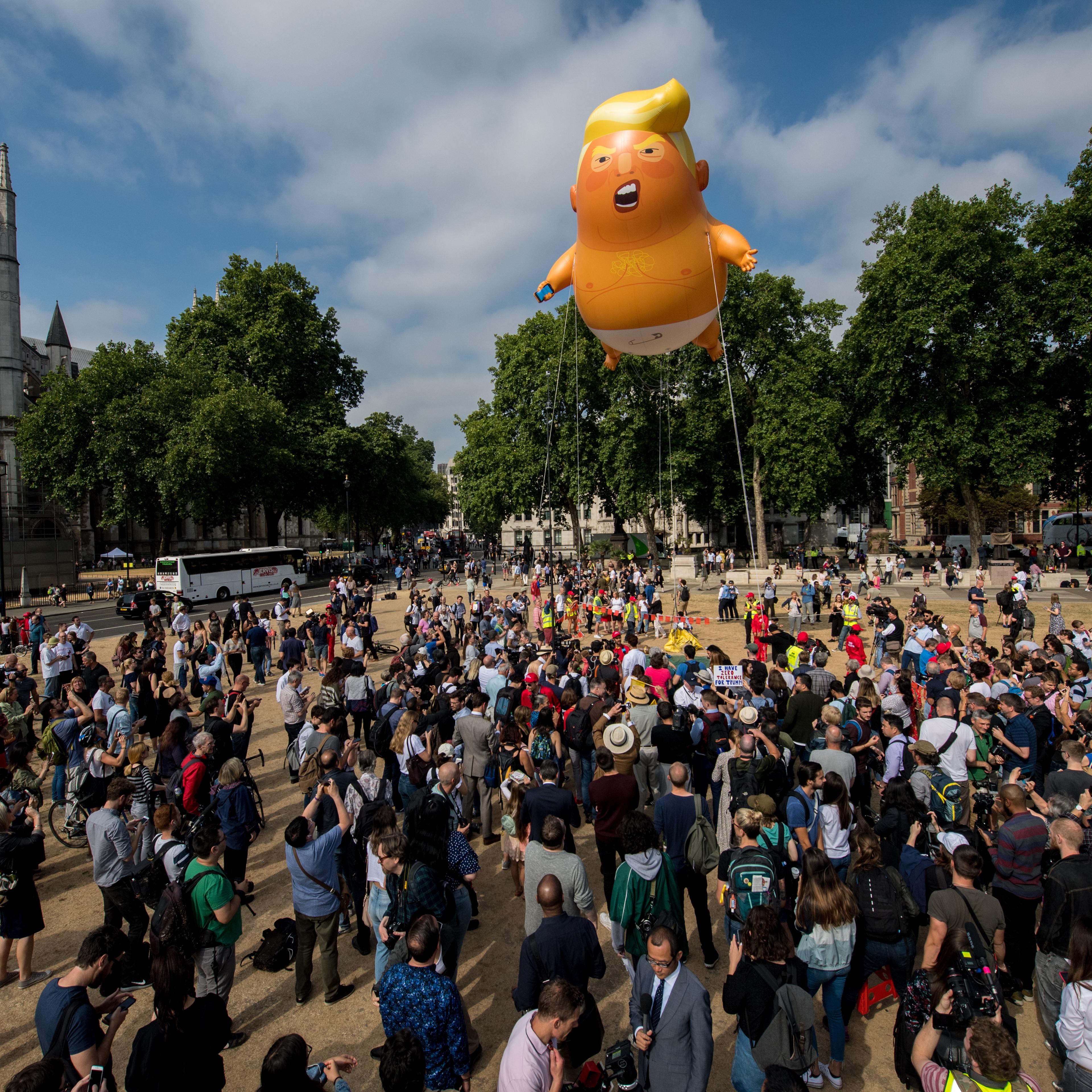 Demonstrators raise a six meter high effigy of Donald Trump, being dubbed the 'Trump Baby', in Parliament Square in protest against the U.S. President's current visit to the United Kingdom on July 13, 2018 in London, United Kingdom.