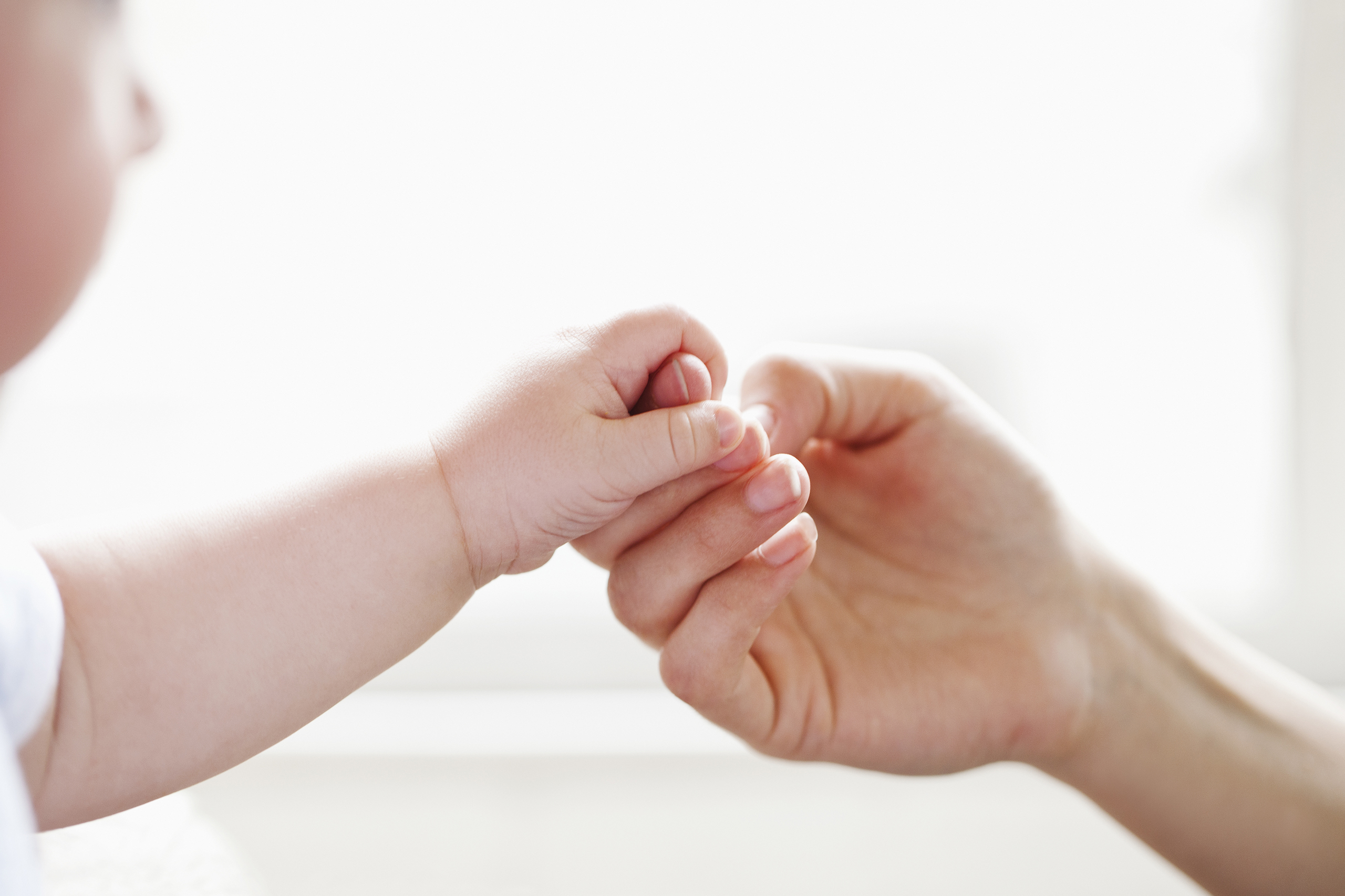 Baby holding mother's finger