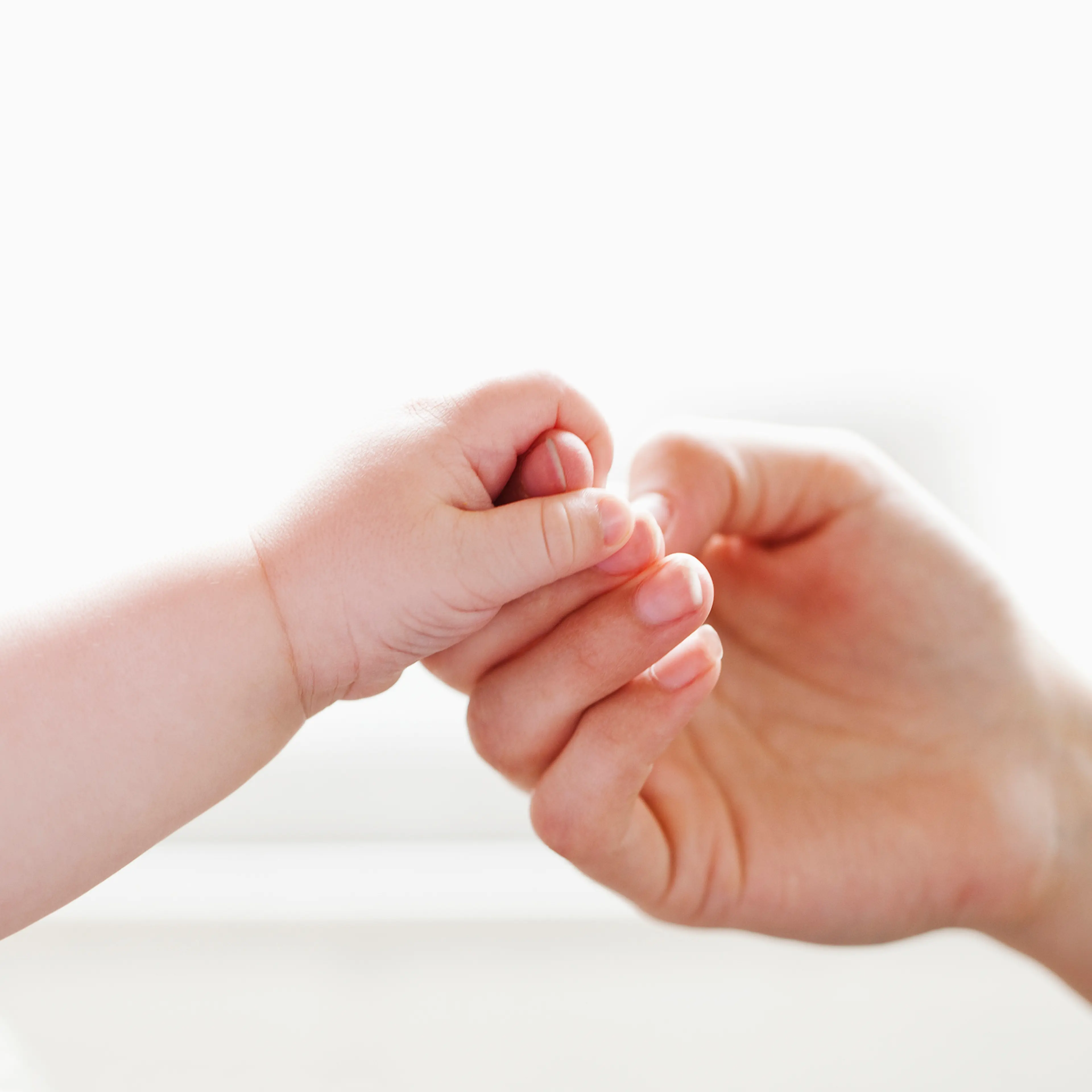 Baby holding mother's finger