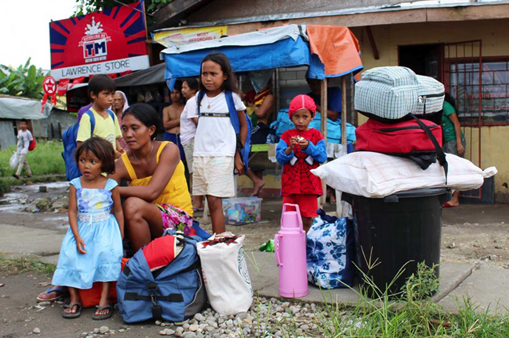 Residents with their belongings wait for a government vehicle to bring them to the evacuation center in Tacloban city, central Philippines, on Dec. 4, 2014