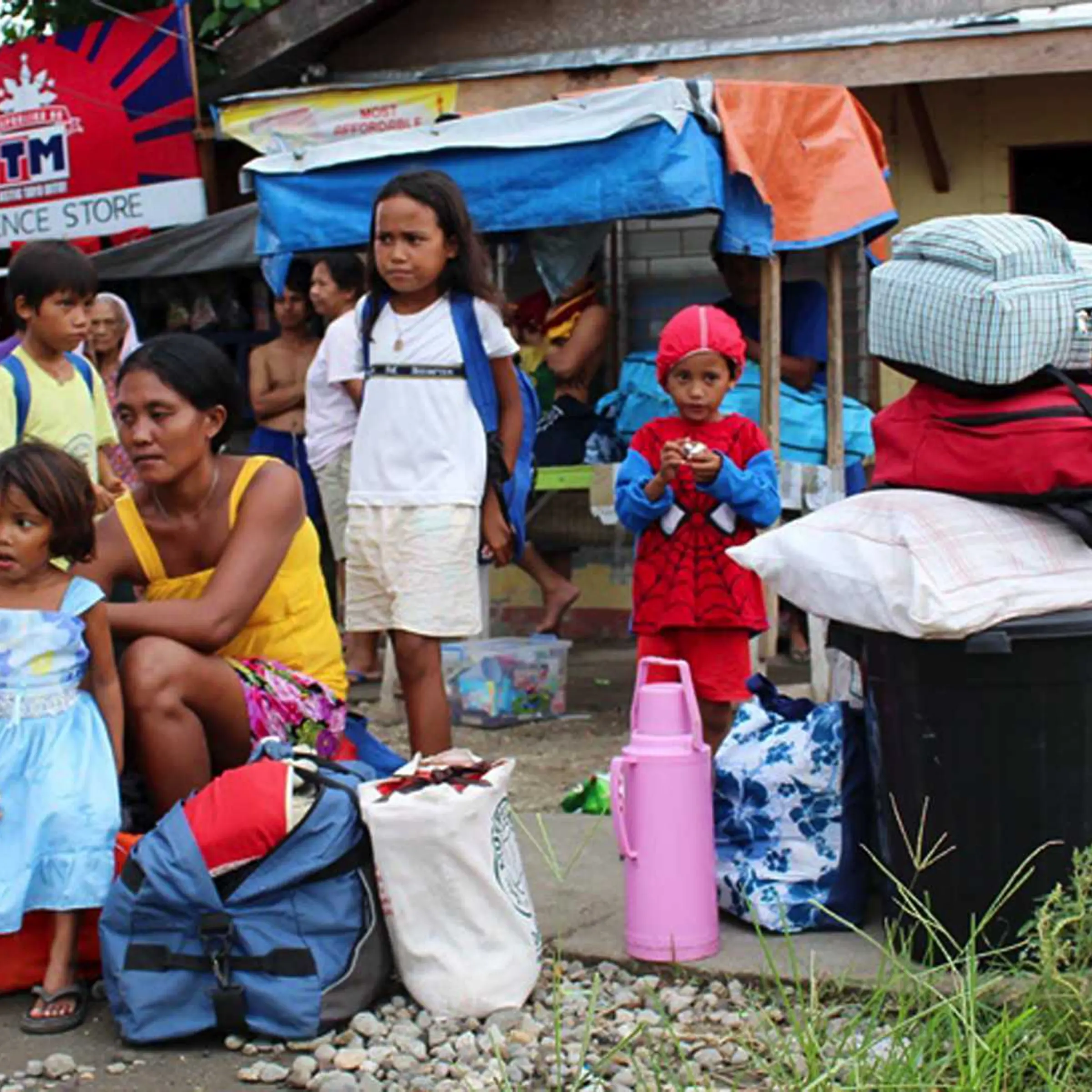 Residents with their belongings wait for a government vehicle to bring them to the evacuation center in Tacloban city, central Philippines, on Dec. 4, 2014
