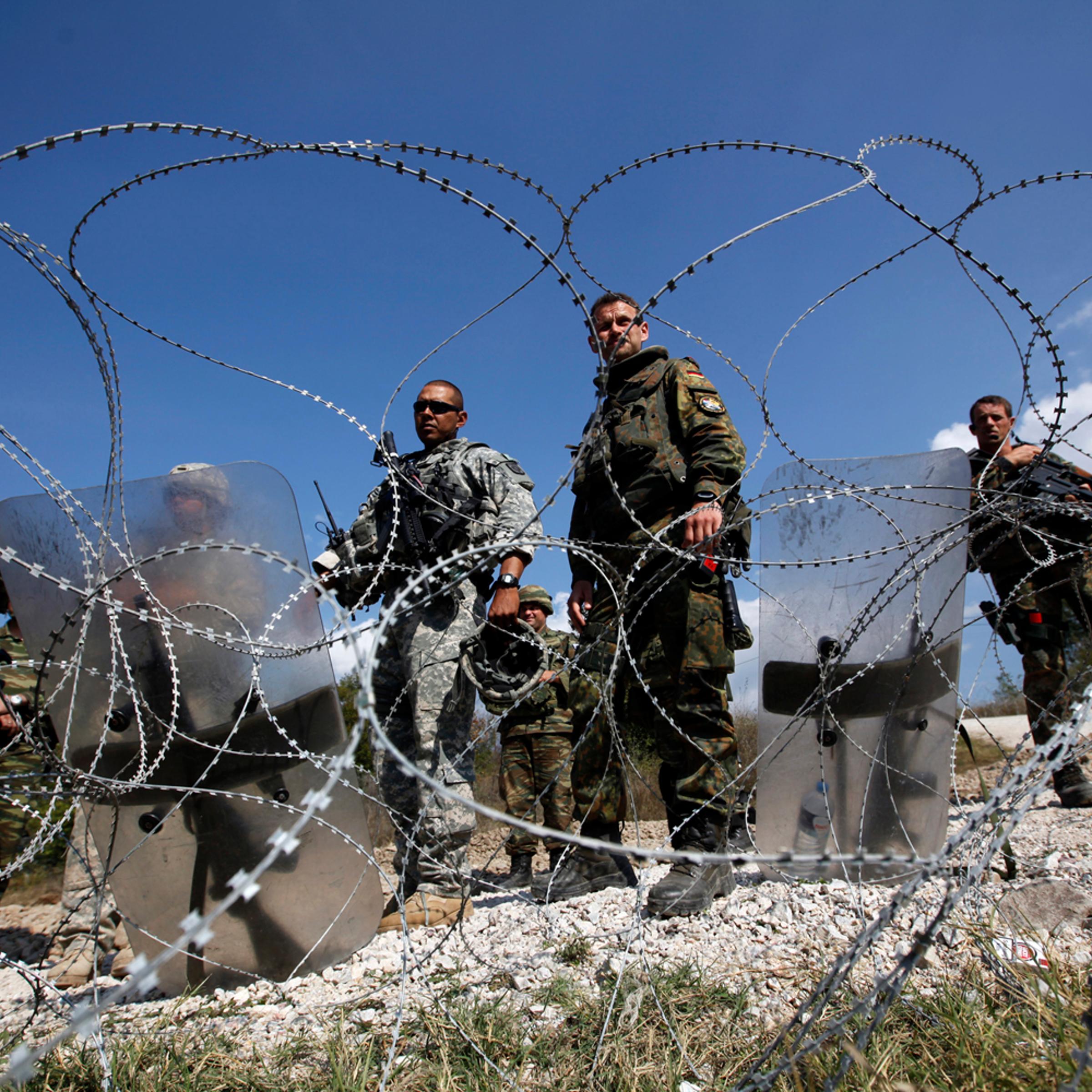 Kosovo Force (KFOR) soldiers from Greece, Germany and the U.S. stand guard at the closed Serbia-Kosovo border crossing of Jarinje