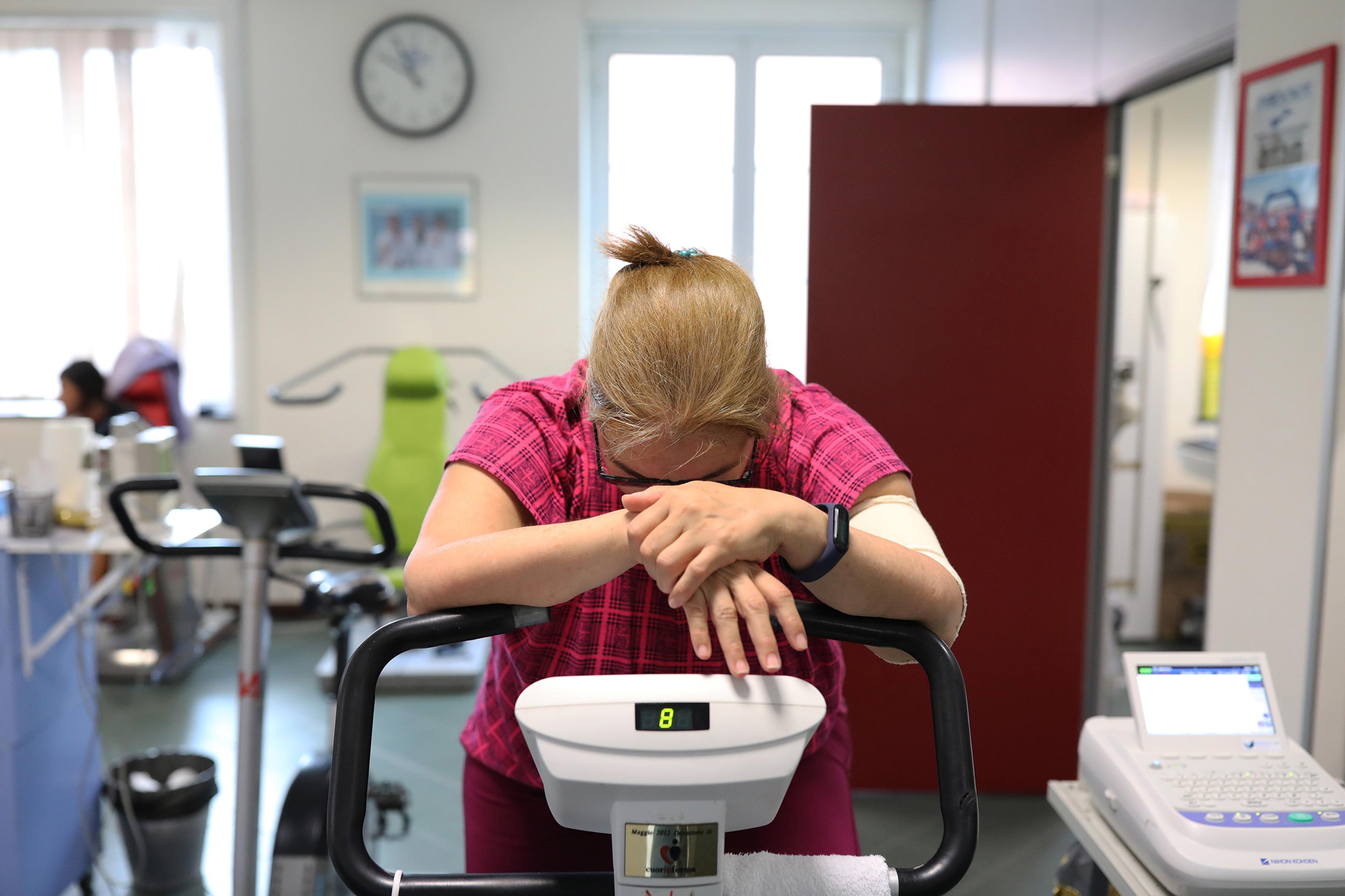 A former COVID-19 patient rides on an exercise bike to strengthen muscle tone at the Department of Rehabilitative Cardiology of ASL 3 Genova on July 24 in Genoa, Italy. She contracted Covid-19 and remained in hospital for 15 days, currently suffering fro