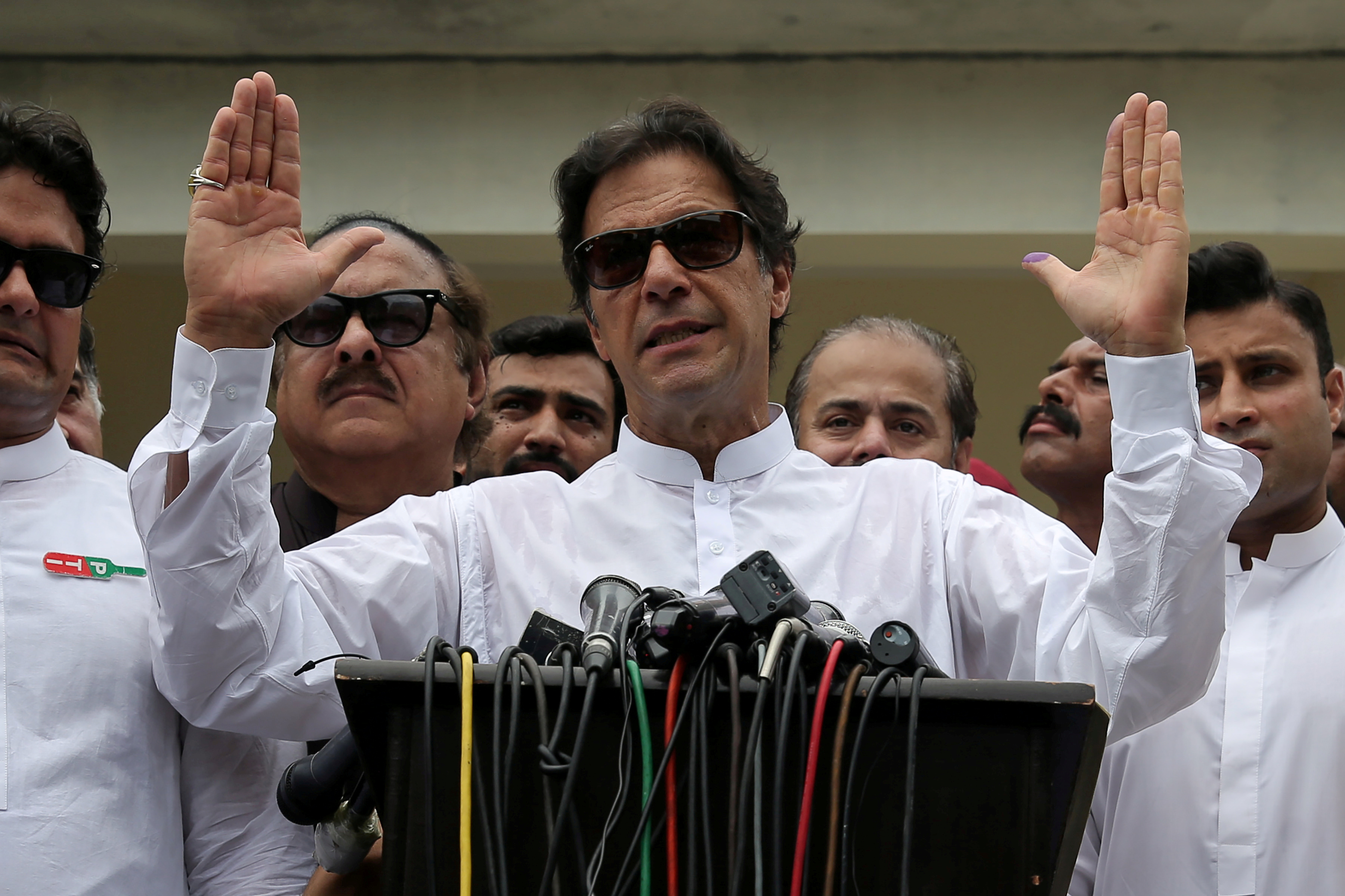 Imran Khan speaks to members of media after casting his vote at a polling station during the general election in Islamabad