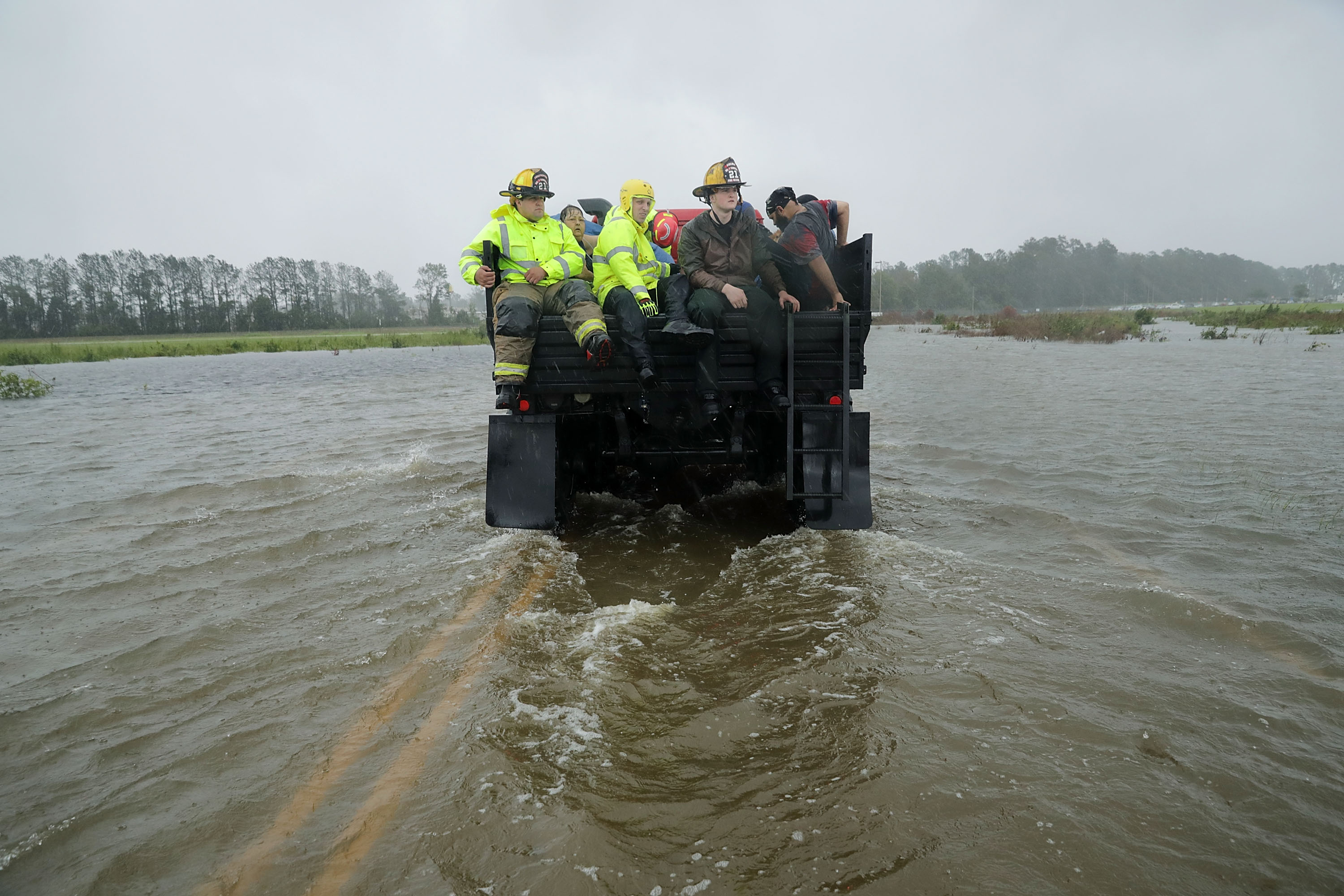 Rescue workers driving through a flooded road