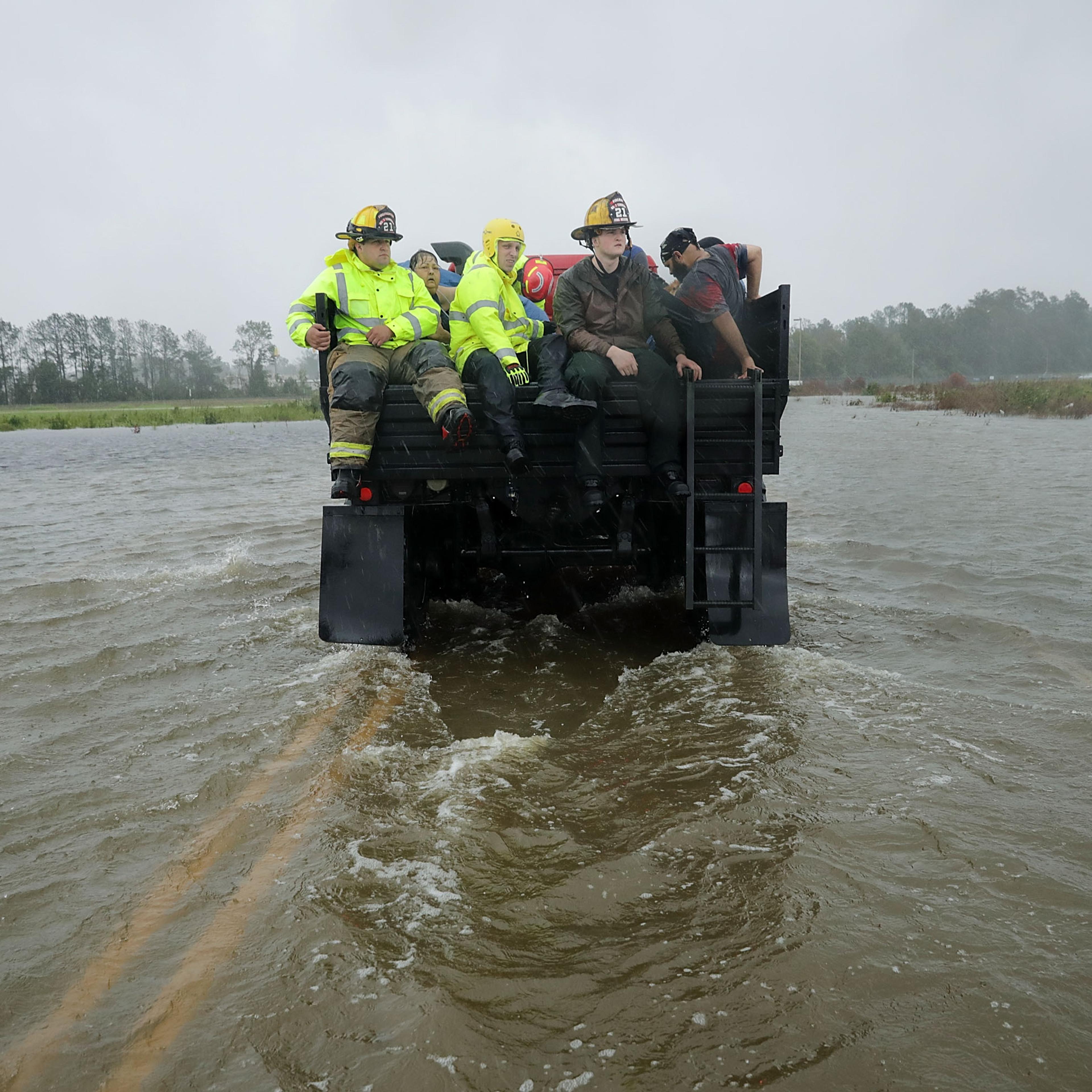Rescue workers driving through a flooded road