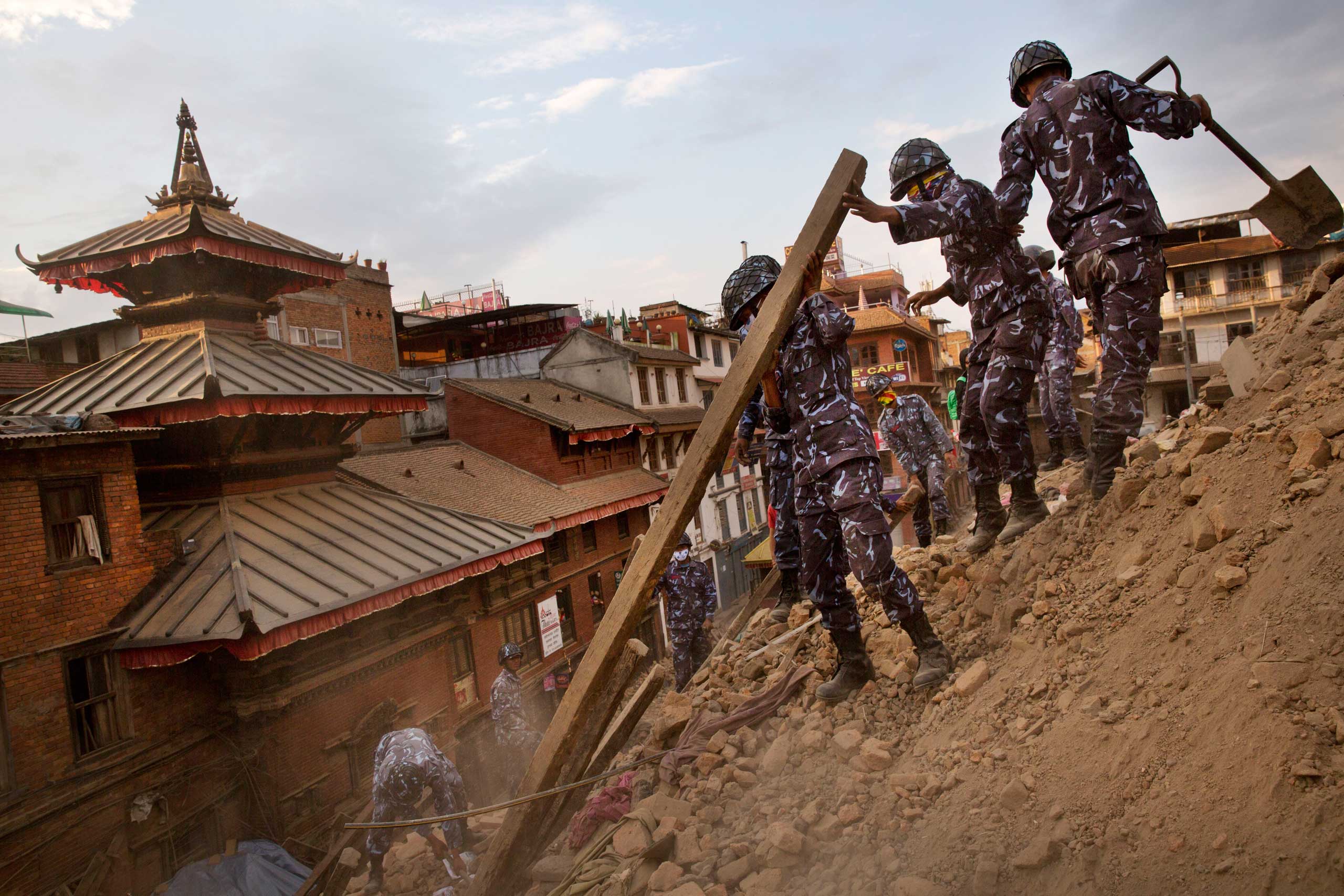Nepalese policemen clear the debris at Basantapur Durbar Square, damaged in Saturday's earthquake, in Kathmandu on April 26, 2015.