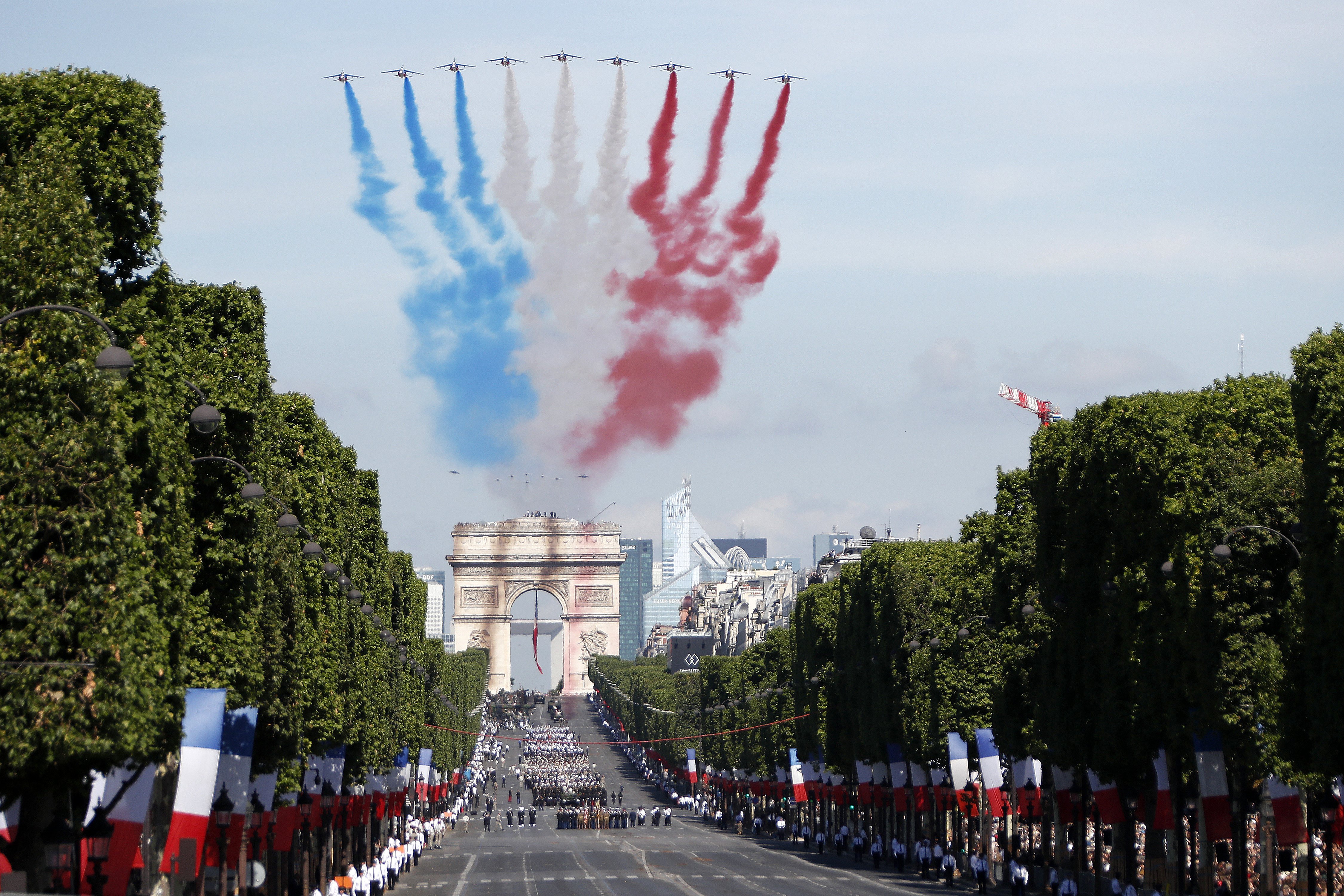Alpha jets fly over the Arc de Triomphe leaving a red, white and blue trail during the annual Bastille Day celebrations in Paris, July 14, 2017.