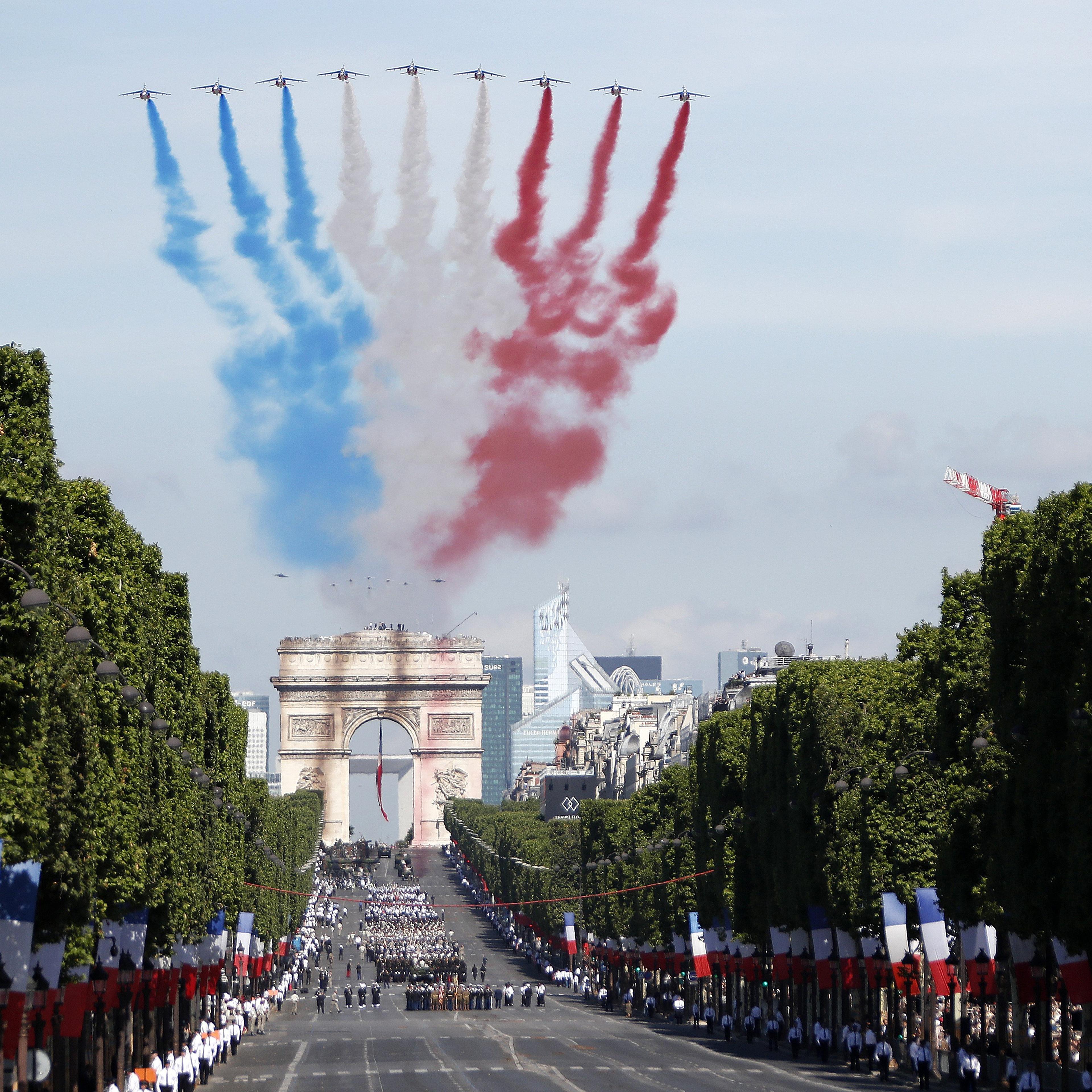 Alpha jets fly over the Arc de Triomphe leaving a red, white and blue trail during the annual Bastille Day celebrations in Paris, July 14, 2017.