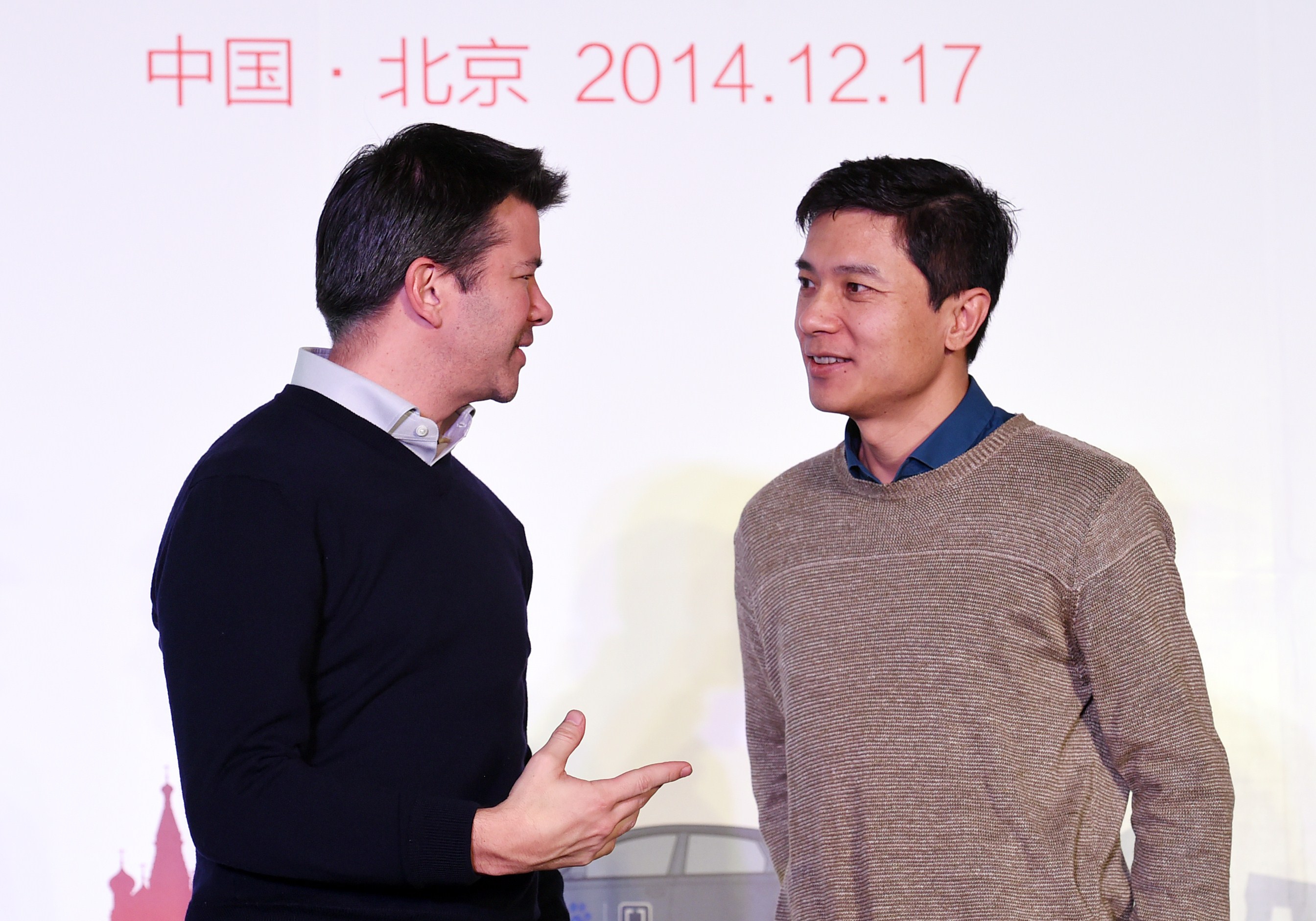 Uber CEO Travis Kalanick (L) and Baidu Chairman and CEO Robin Li at a signing ceremony and press conference in Beijing on Dec. 17, 2014.