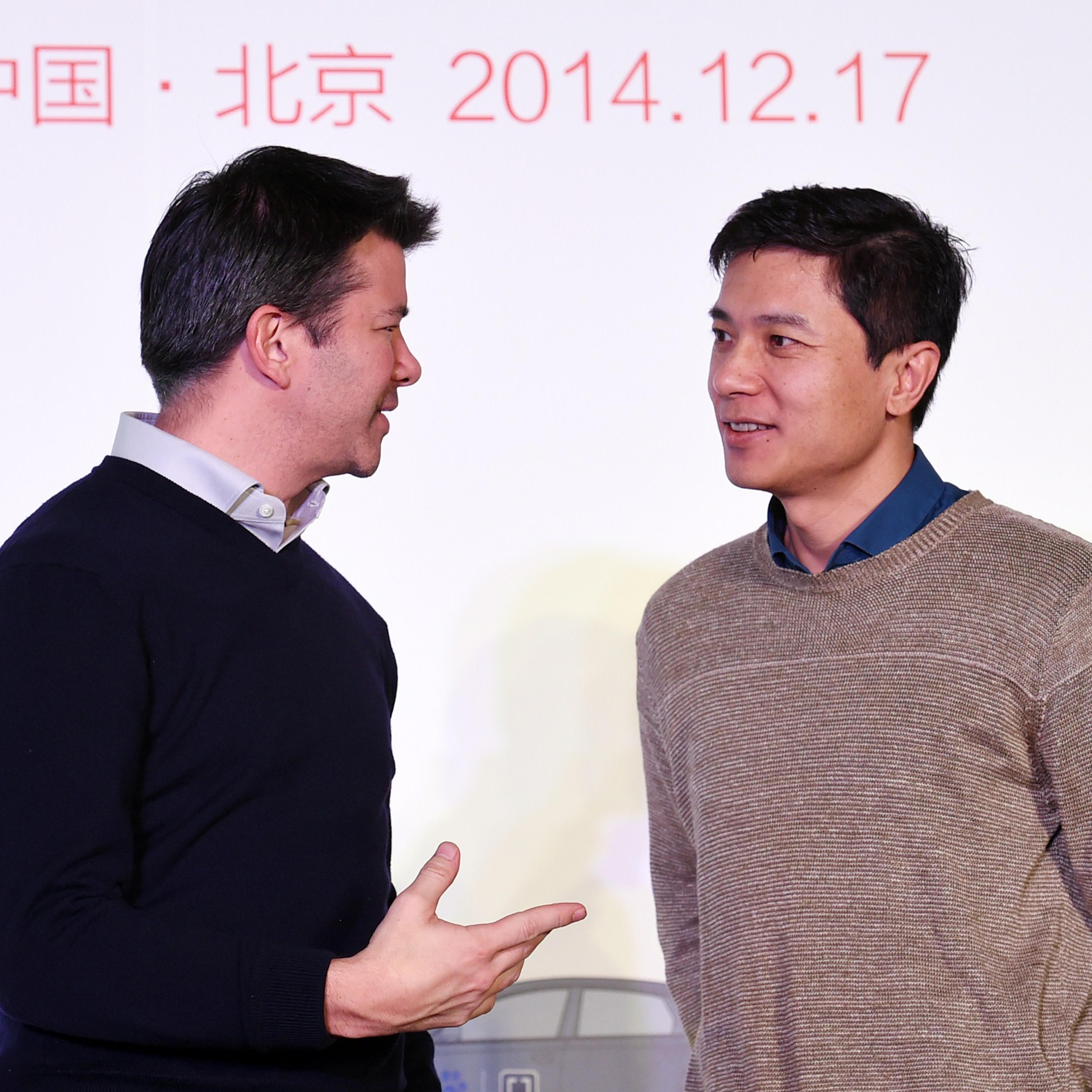 Uber CEO Travis Kalanick (L) and Baidu Chairman and CEO Robin Li at a signing ceremony and press conference in Beijing on Dec. 17, 2014.