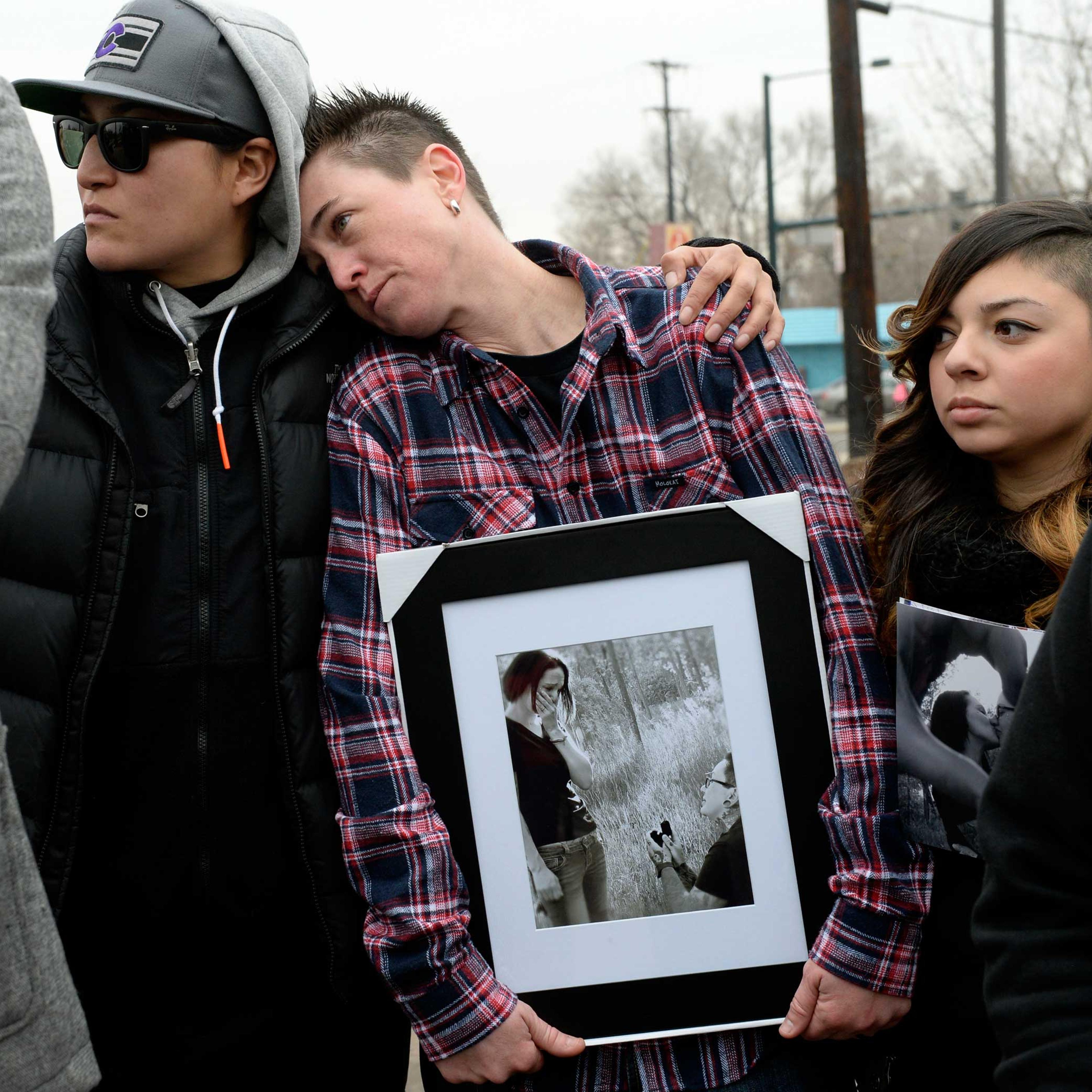 Cheyenne Poorbear, Samantha Getman and Victoria Quintana display photographs of Vanessa Collier and her partner, Christina Higley, during a rally outside New Hope Ministries in Lakewood, Colo. Jan. 13, 2015.