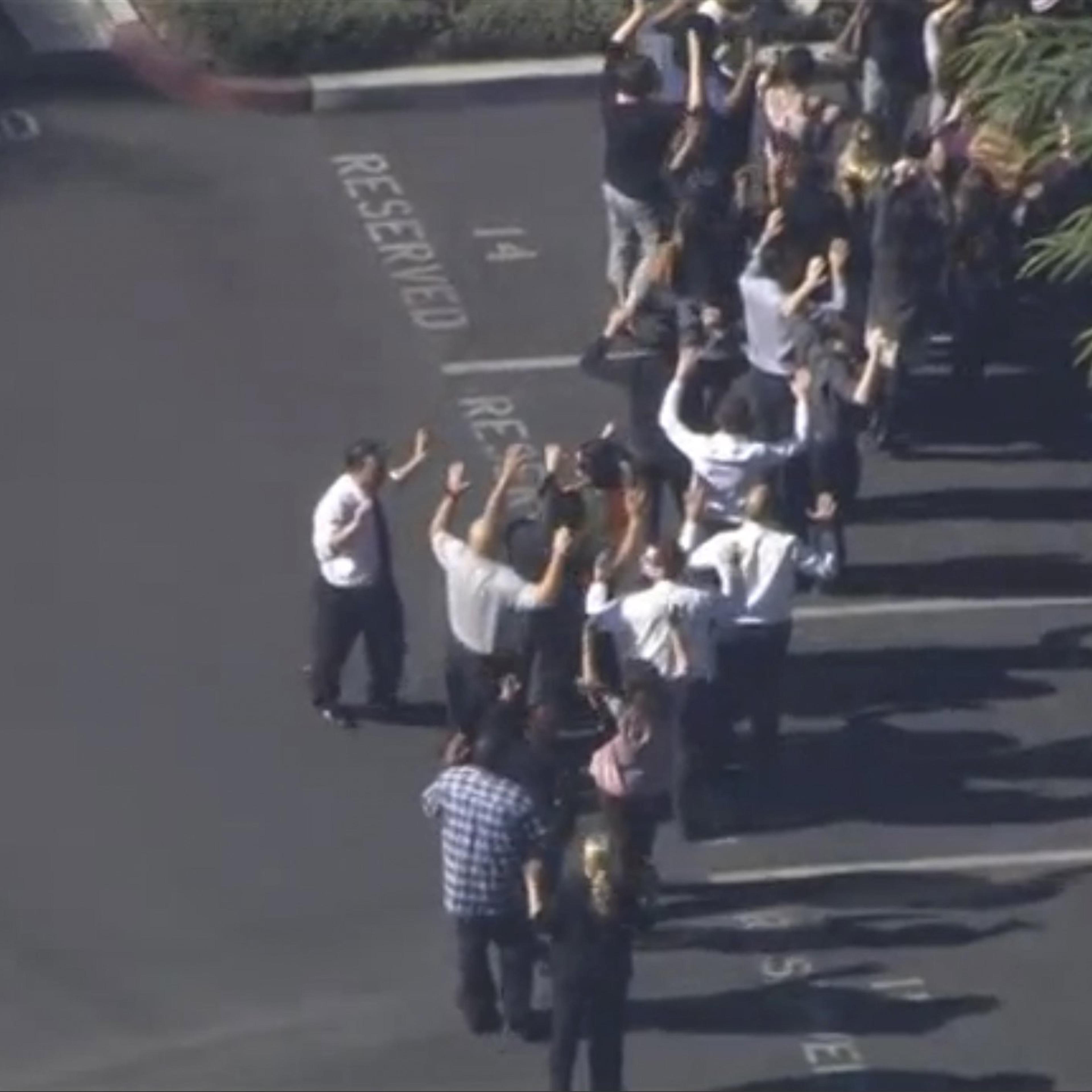 A still image from a video footage courtesy of Nbcla.com shows people lining up as first responders respond to shooting in San Bernardino California