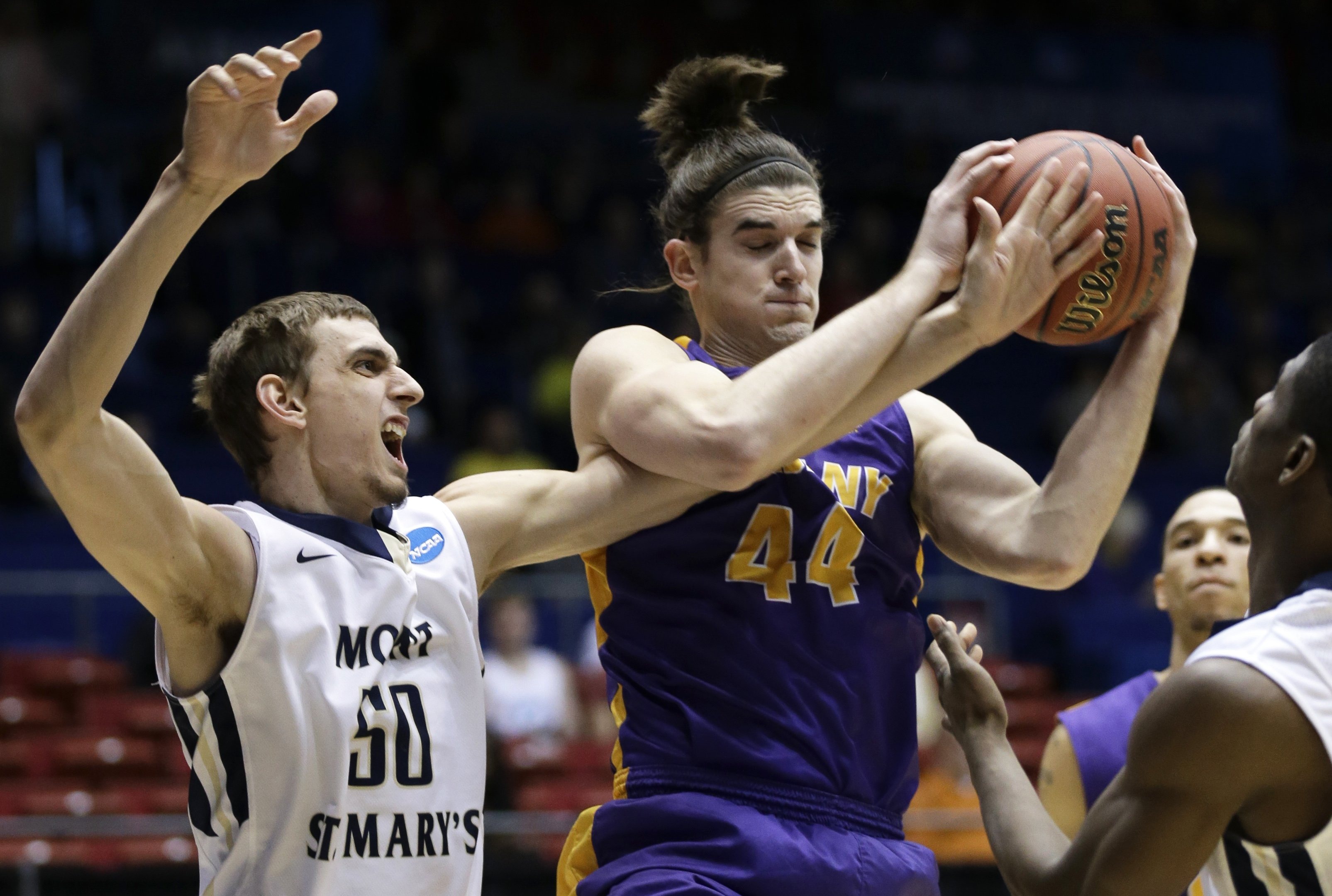 Albany center John Puk pulls a rebound away from Mount St. Mary's center Taylor Danaher in the first half of a first-round game of the NCAA college basketball tournament