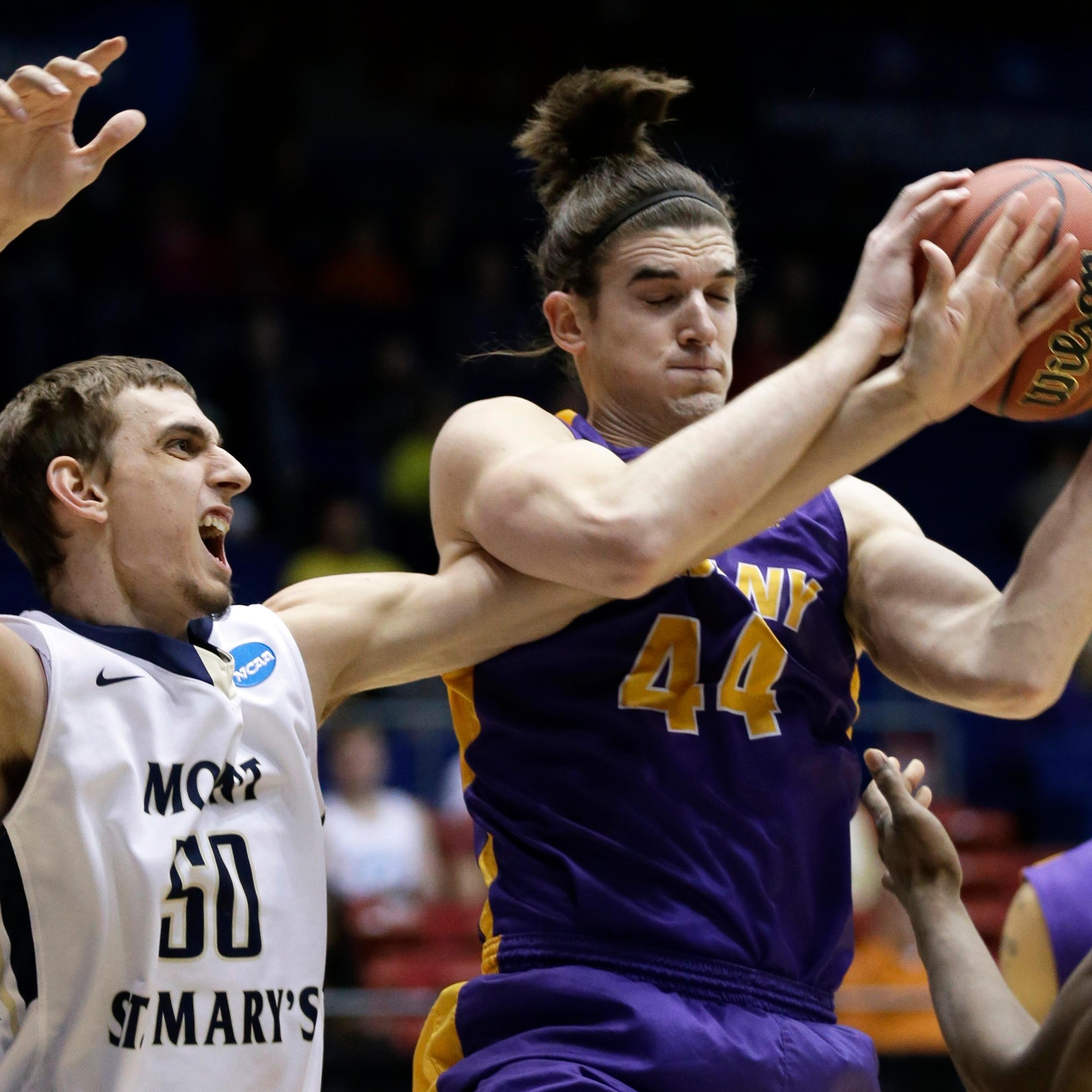 Albany center John Puk pulls a rebound away from Mount St. Mary's center Taylor Danaher in the first half of a first-round game of the NCAA college basketball tournament