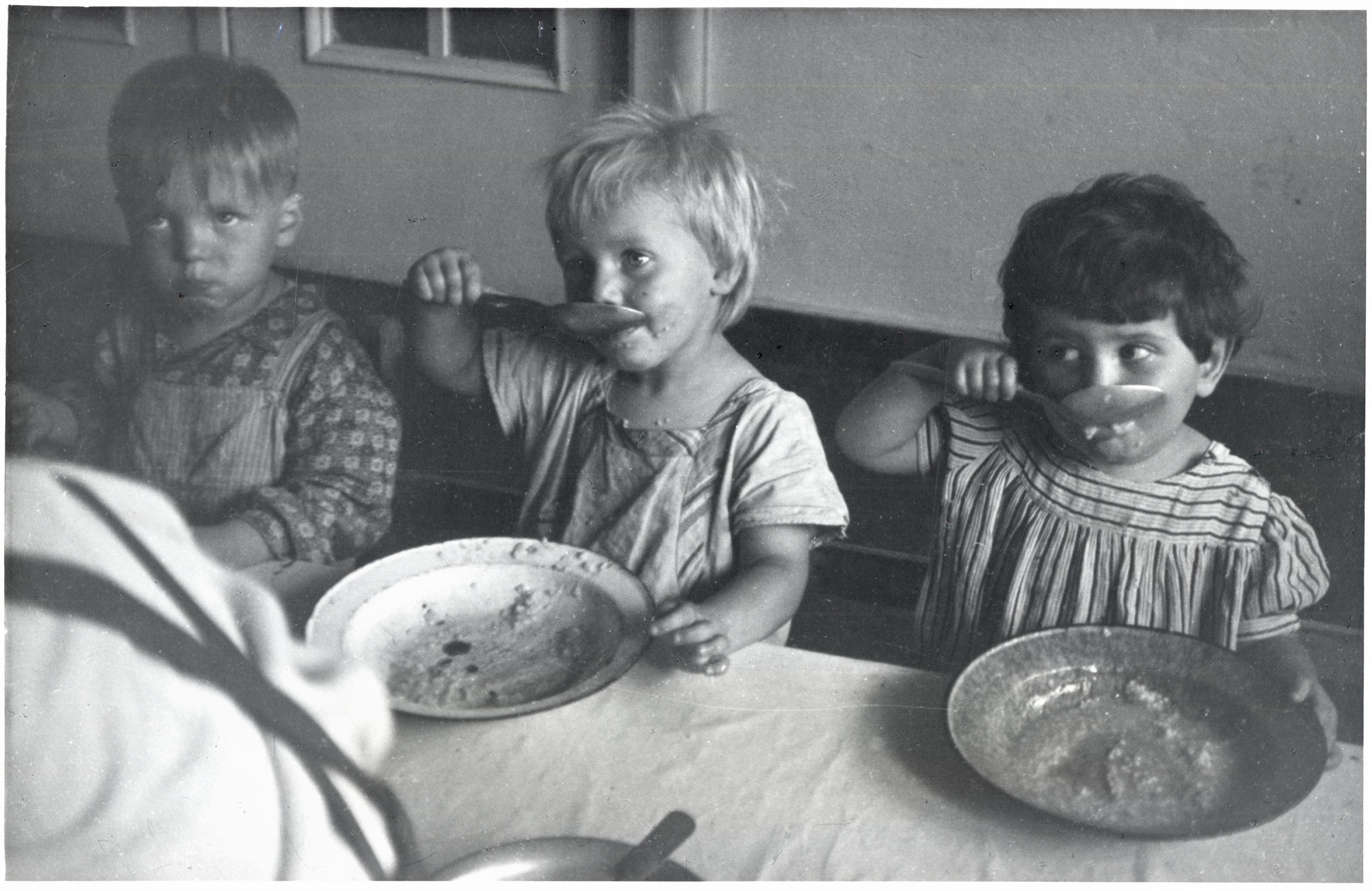 Children eating lunch at a day care center in Sczeczyn; the centers were designed to care for children whose mothers had to work. Sczeczyn, Poland, 1948.