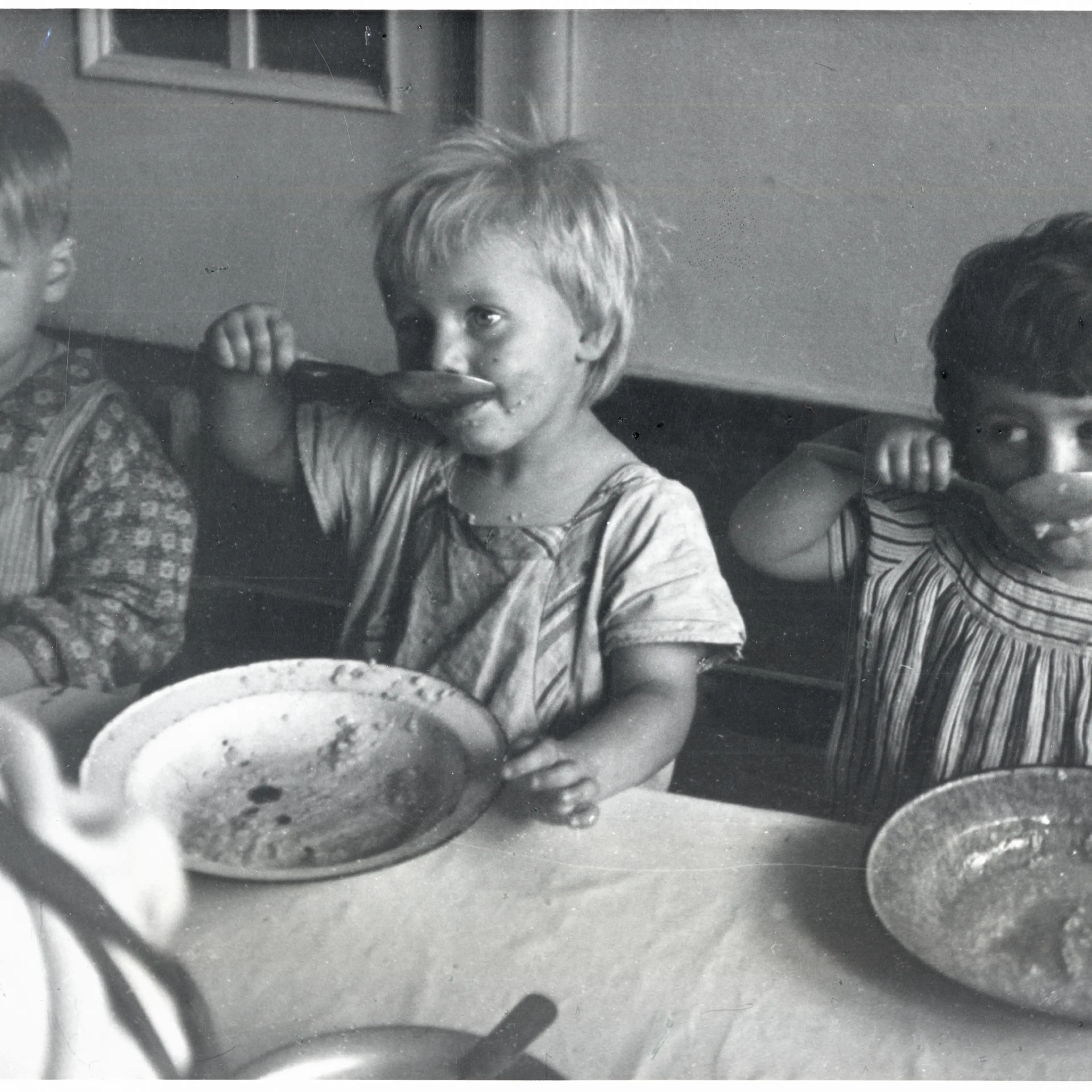 Children eating lunch at a day care center in Sczeczyn; the centers were designed to care for children whose mothers had to work. Sczeczyn, Poland, 1948.