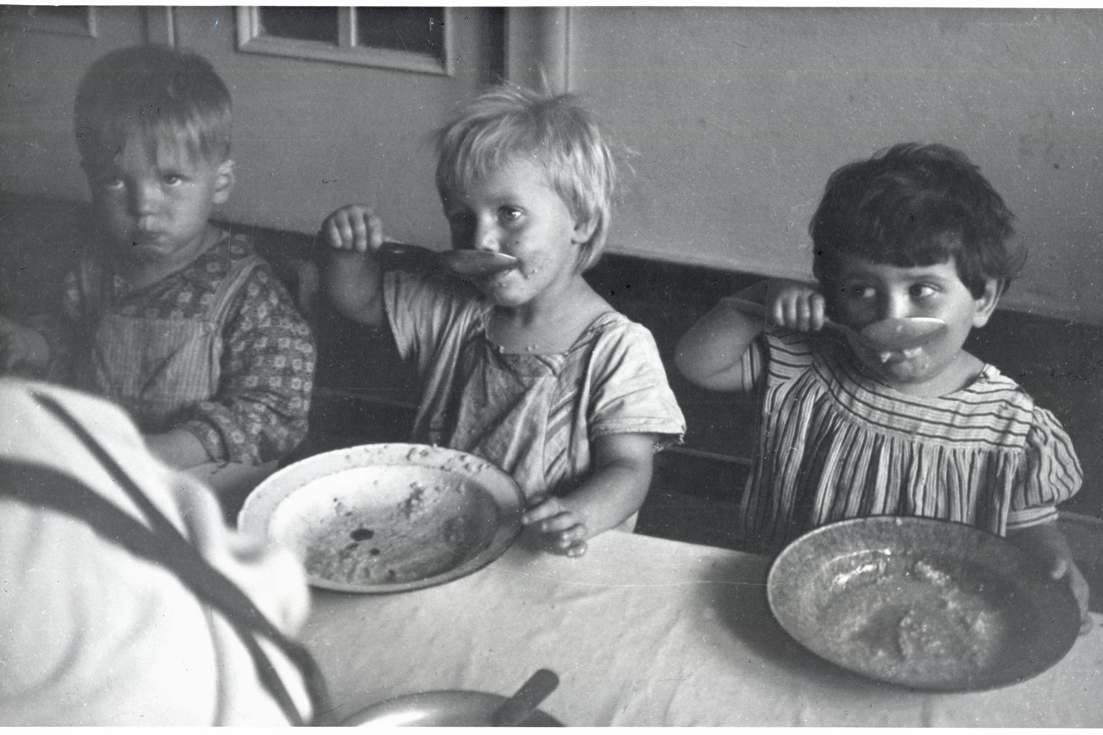 Children eating lunch at a day care center in Sczeczyn; the centers were designed to care for children whose mothers had to work. Sczeczyn, Poland, 1948.