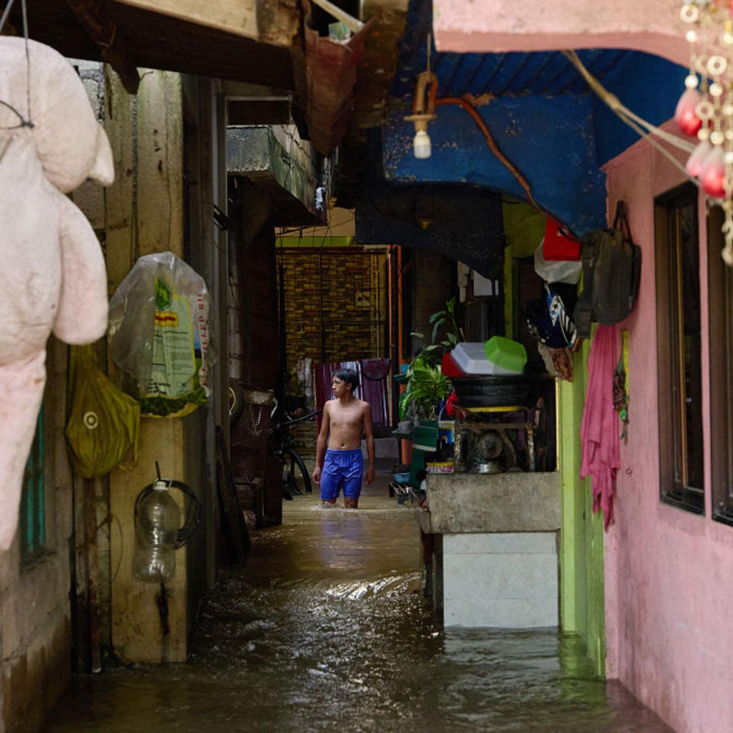 A man wades past flooded houses due to a swollen river caused by heavy rains and induced by Super Typhoon Man-yi in Tuguegarao City, Cagayan province, Philippines on Nov. 19, 2024.