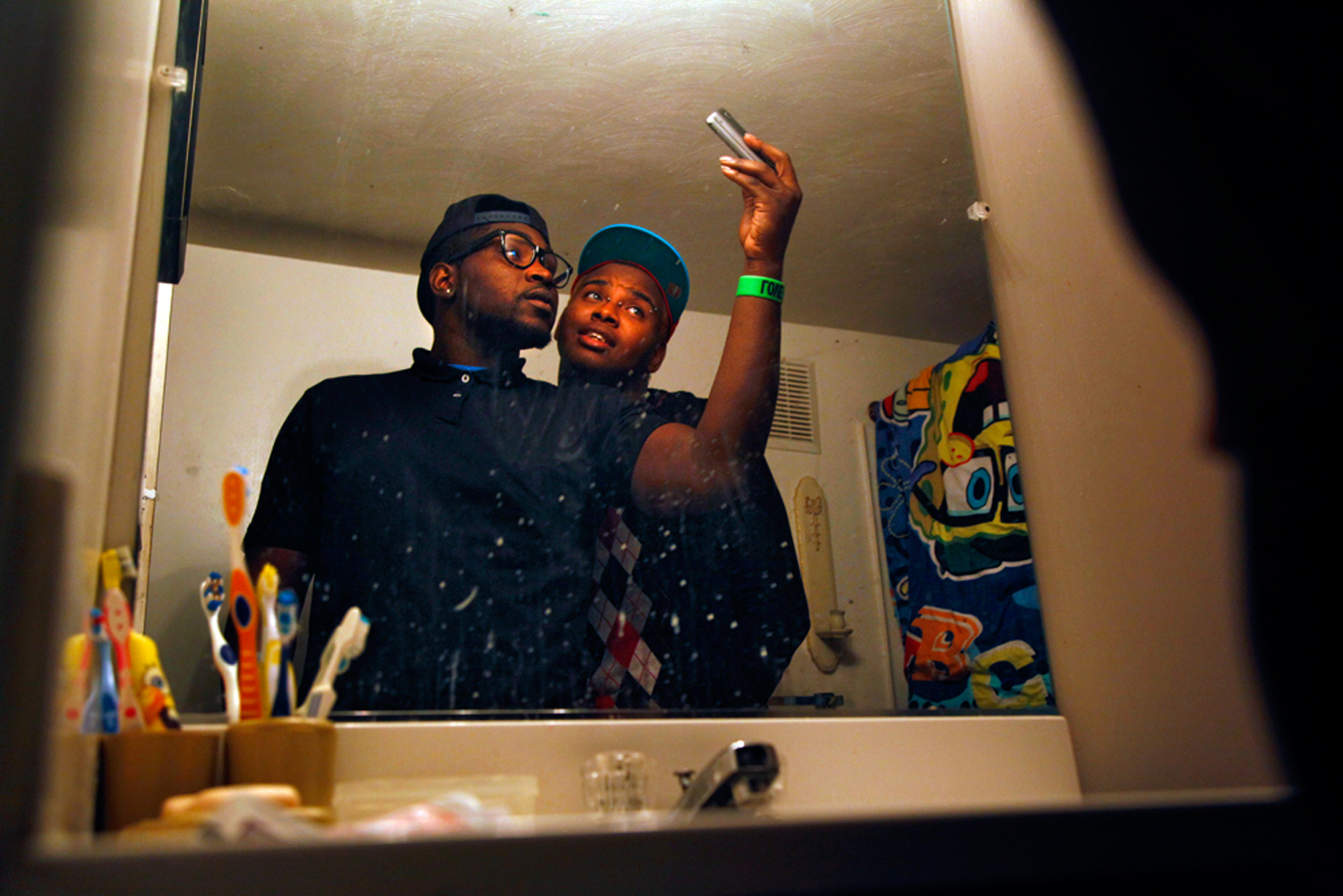 Teddy and his best friend Jamesie Johnson take self-portraits for Facebook in Jamesie's bathroom. 