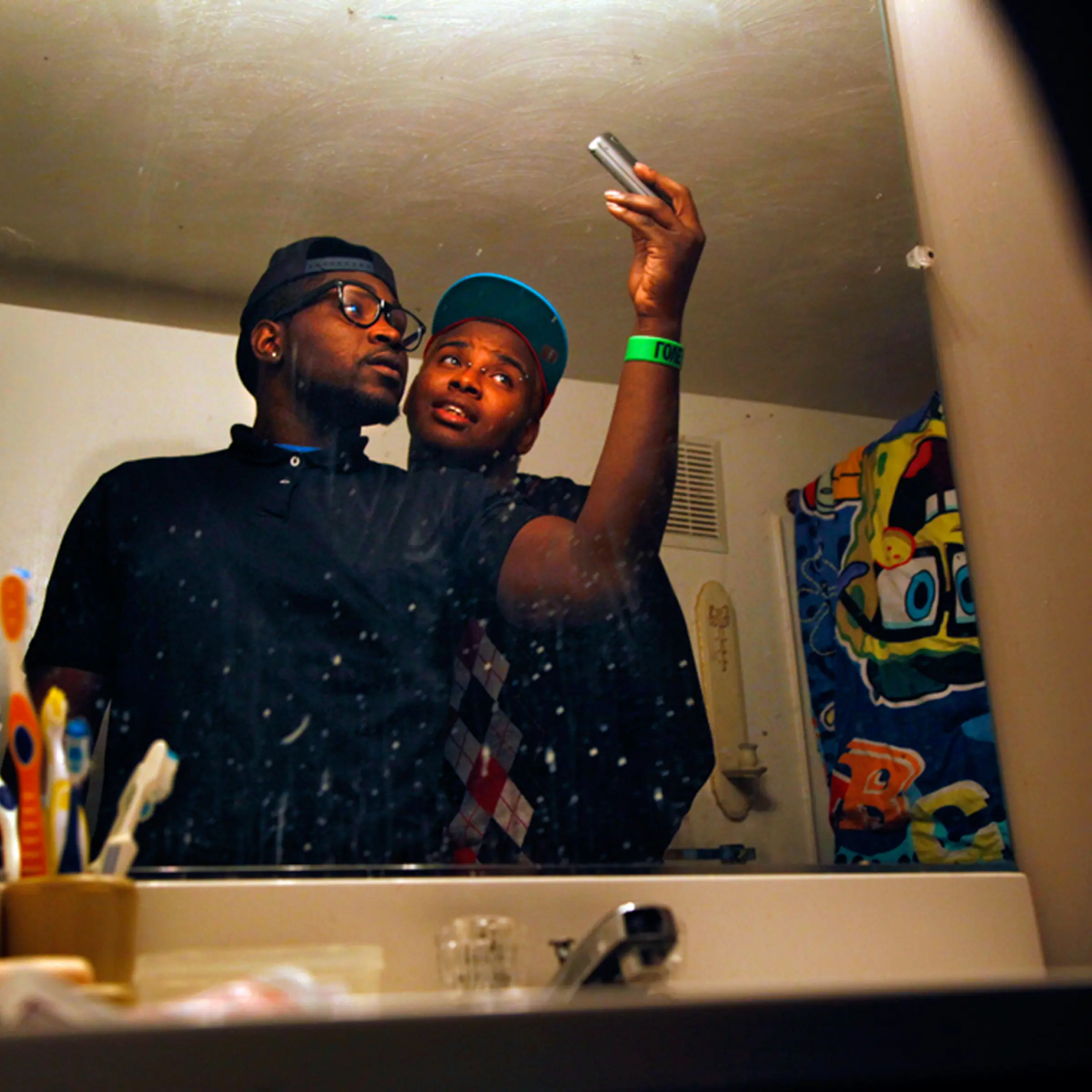 Teddy and his best friend Jamesie Johnson take self-portraits for Facebook in Jamesie's bathroom.
