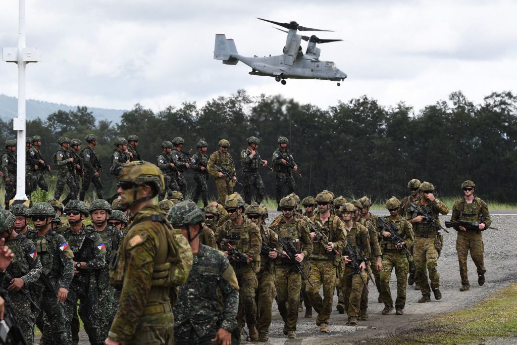 Philippine and Australian soldiers march in formation while a US marines V-22 Osprey hovers above during military exercise Alon, a joint amphibious landing drill held at a naval base in San Antonio town in Zambales province, north of Manila on Aug. 25, 2