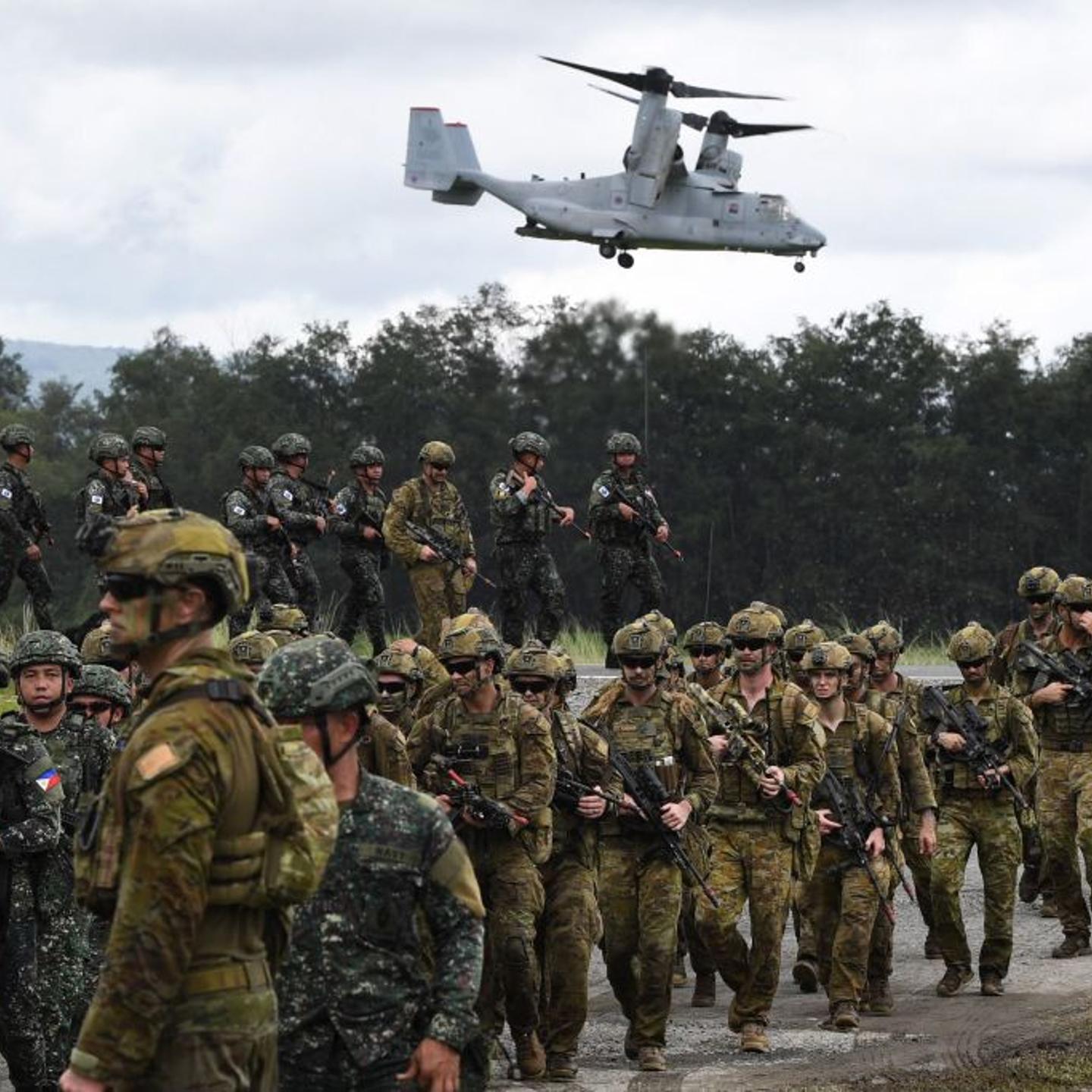 Philippine and Australian soldiers march in formation while a US marines V-22 Osprey hovers above during military exercise Alon, a joint amphibious landing drill held at a naval base in San Antonio town in Zambales province, north of Manila on Aug. 25, 2