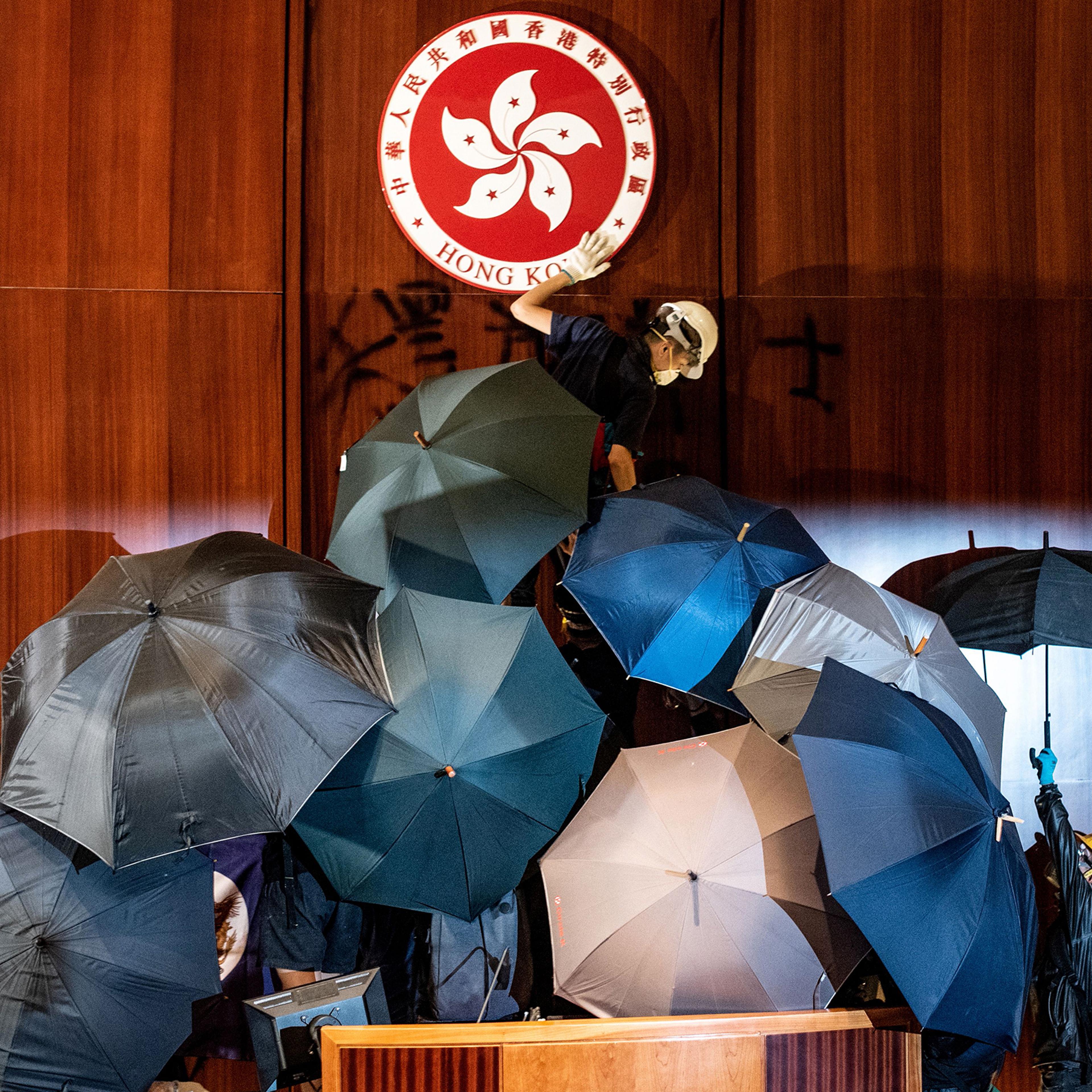 A protester defaces the Hong Kong emblem after protesters broke into the government headquarters on July 1, 2019.