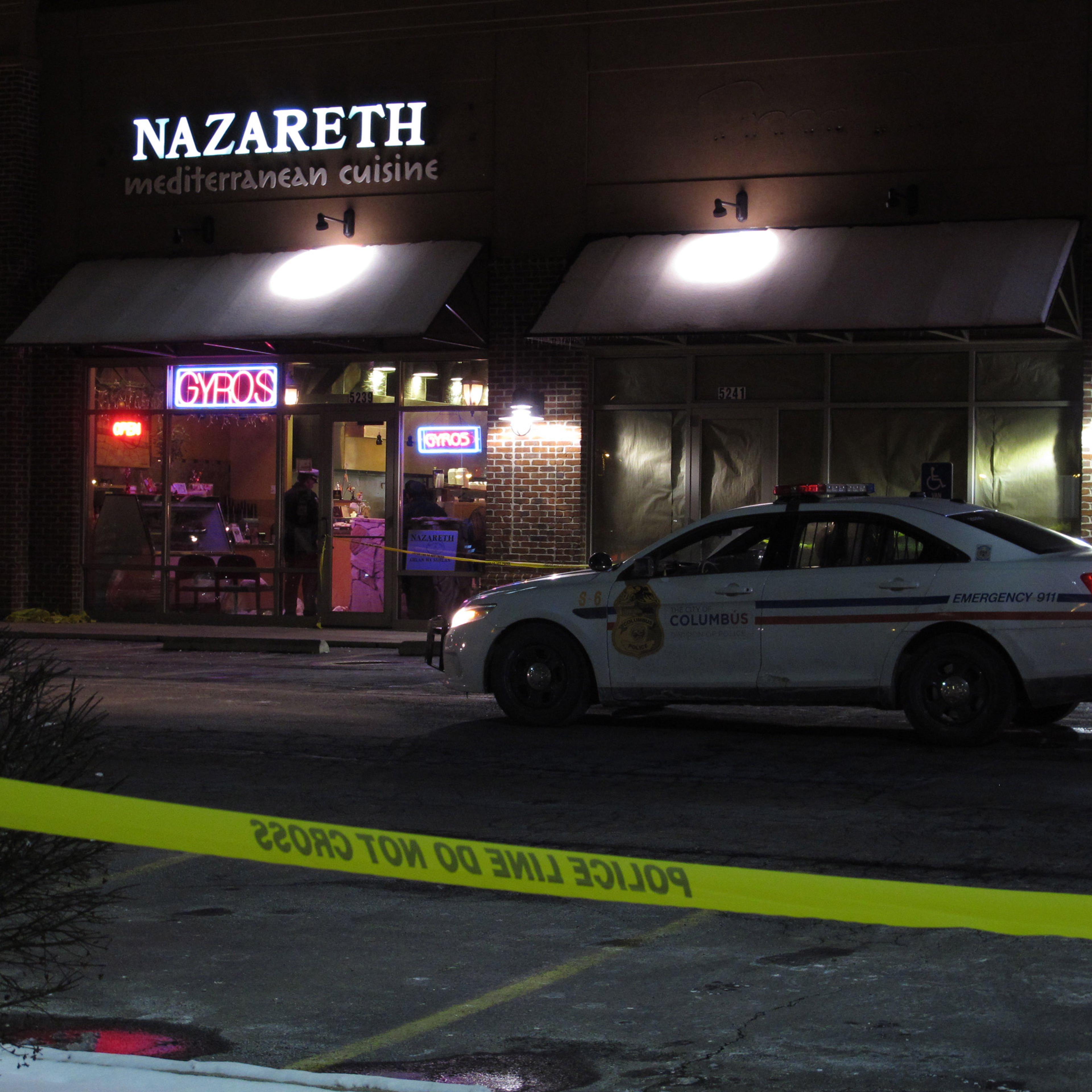 Police talk inside the Columbus, Ohio, restaurant where they say a man attacked several people with a machete on Thursday, Feb. 11, 2016. They say the man fled the scene and was later fatally shot by police. (AP Photo/Kantele Franko)