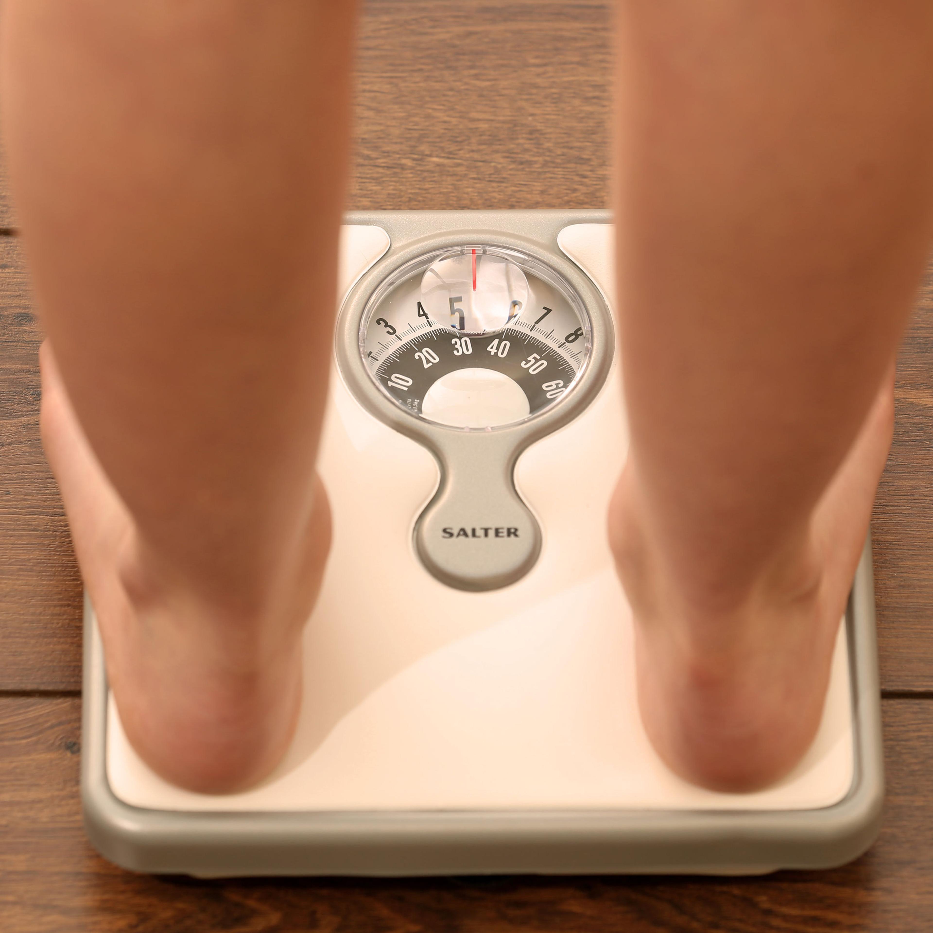 File photo dated Thursday October 16, 2014. of a young girl using a set of weighing scales as slimmers should forget what they have been told about avoiding rapid weight loss in favour of slow but sure dieting, according to new research.