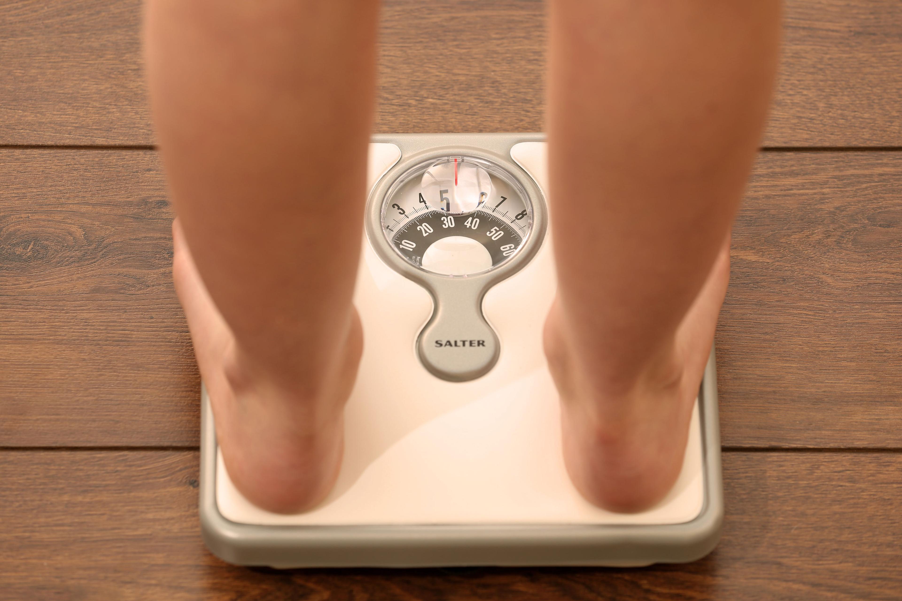File photo dated Thursday October 16, 2014. of a young girl using a set of weighing scales as slimmers should forget what they have been told about avoiding rapid weight loss in favour of slow but sure dieting, according to new research.