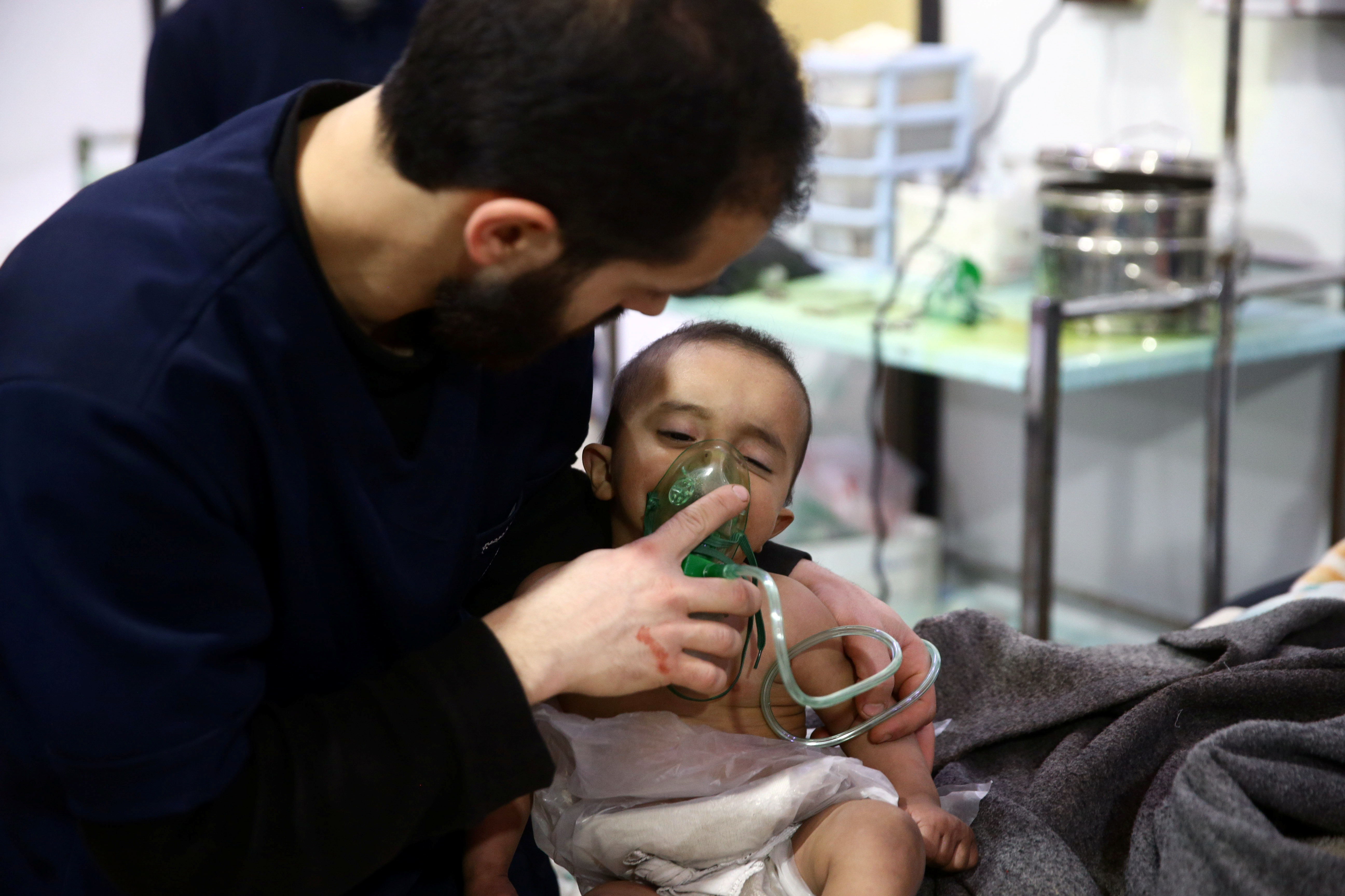 Man with a child are seen in hospital in the besieged town of Douma, Eastern Ghouta, Damascus
