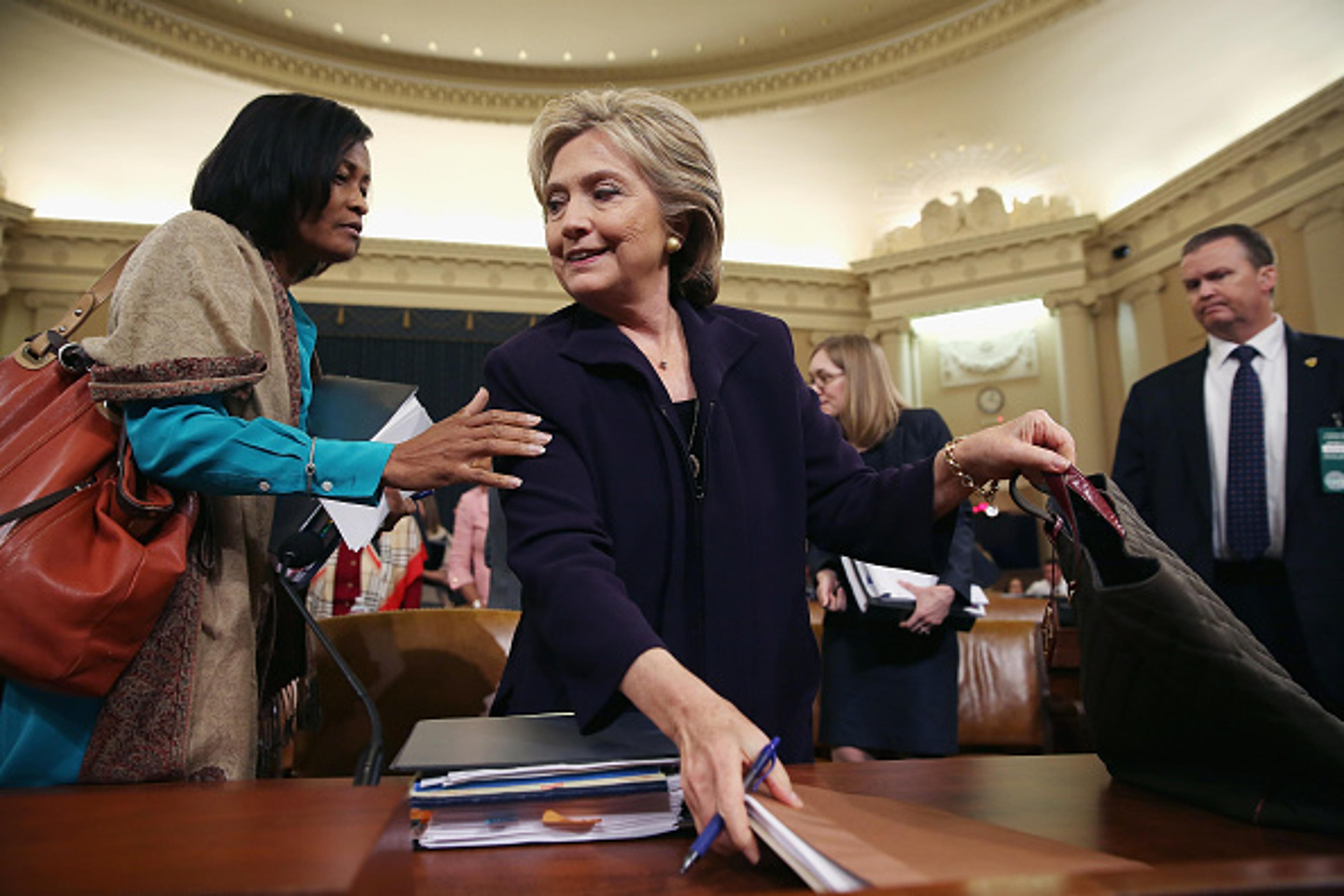 Former State Department Chief of Staff Cheryl Mills (L) and Democratic presidential candidate and former Secretary of State Hillary Clinton take a break in a hearing of the House Select Committee on Benghazi October 22, 2015 on Capitol Hill in Washington